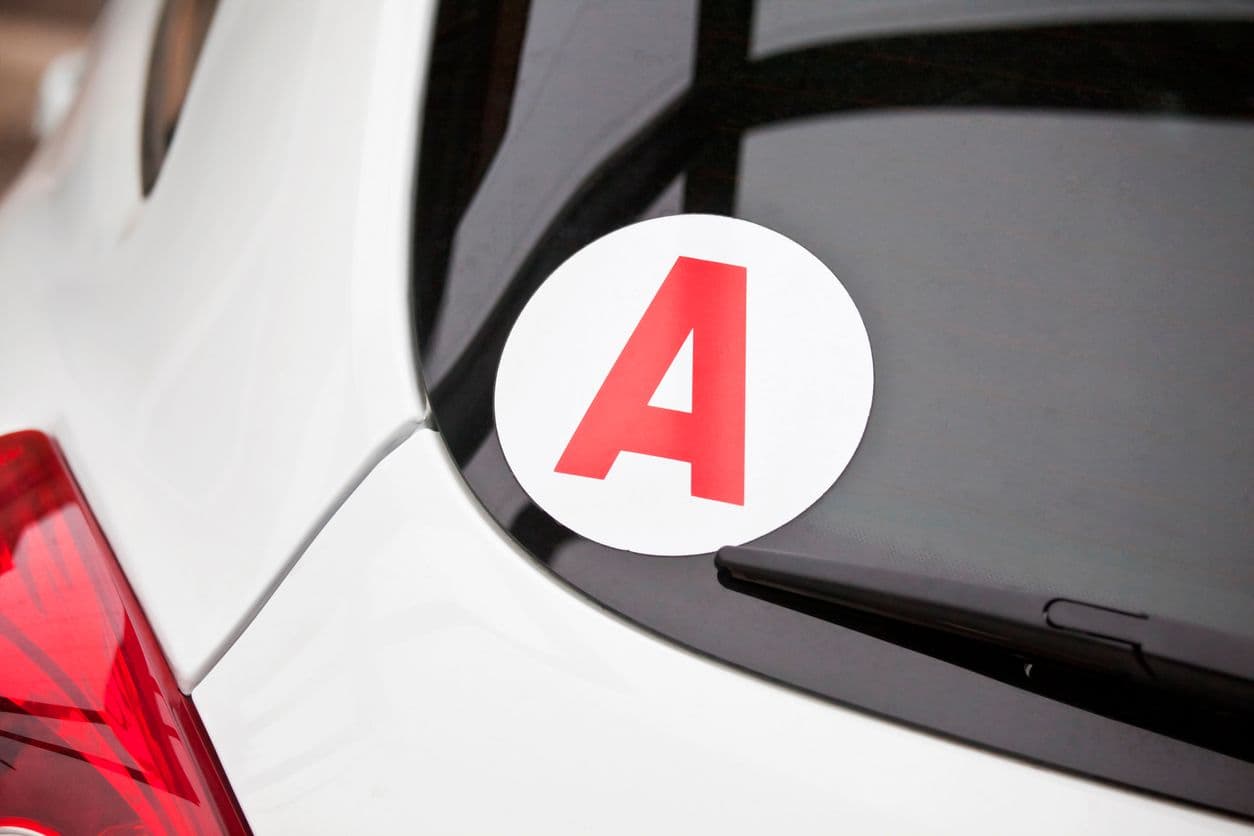 Un sticker "A" apposé au pare-brise arrière d'un véhicule.
