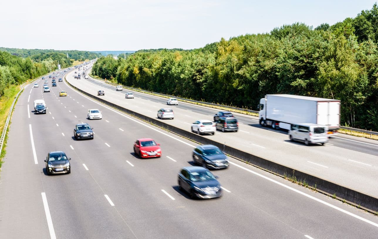 Des voitures et un camion circulent sur l'autoroute en France par une journée ensoleillée