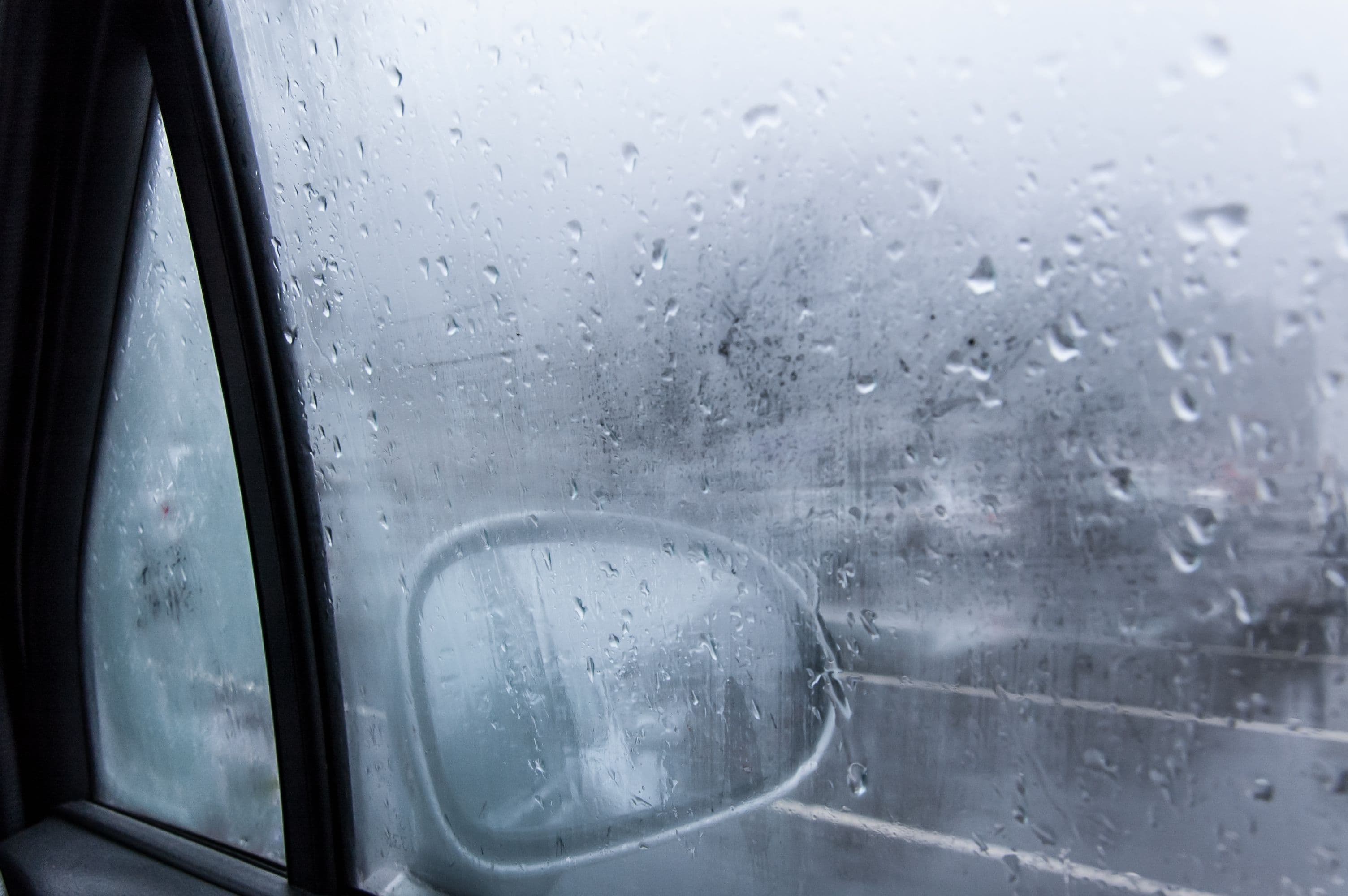 Photo de la buée sur une vitre d'une voiture.