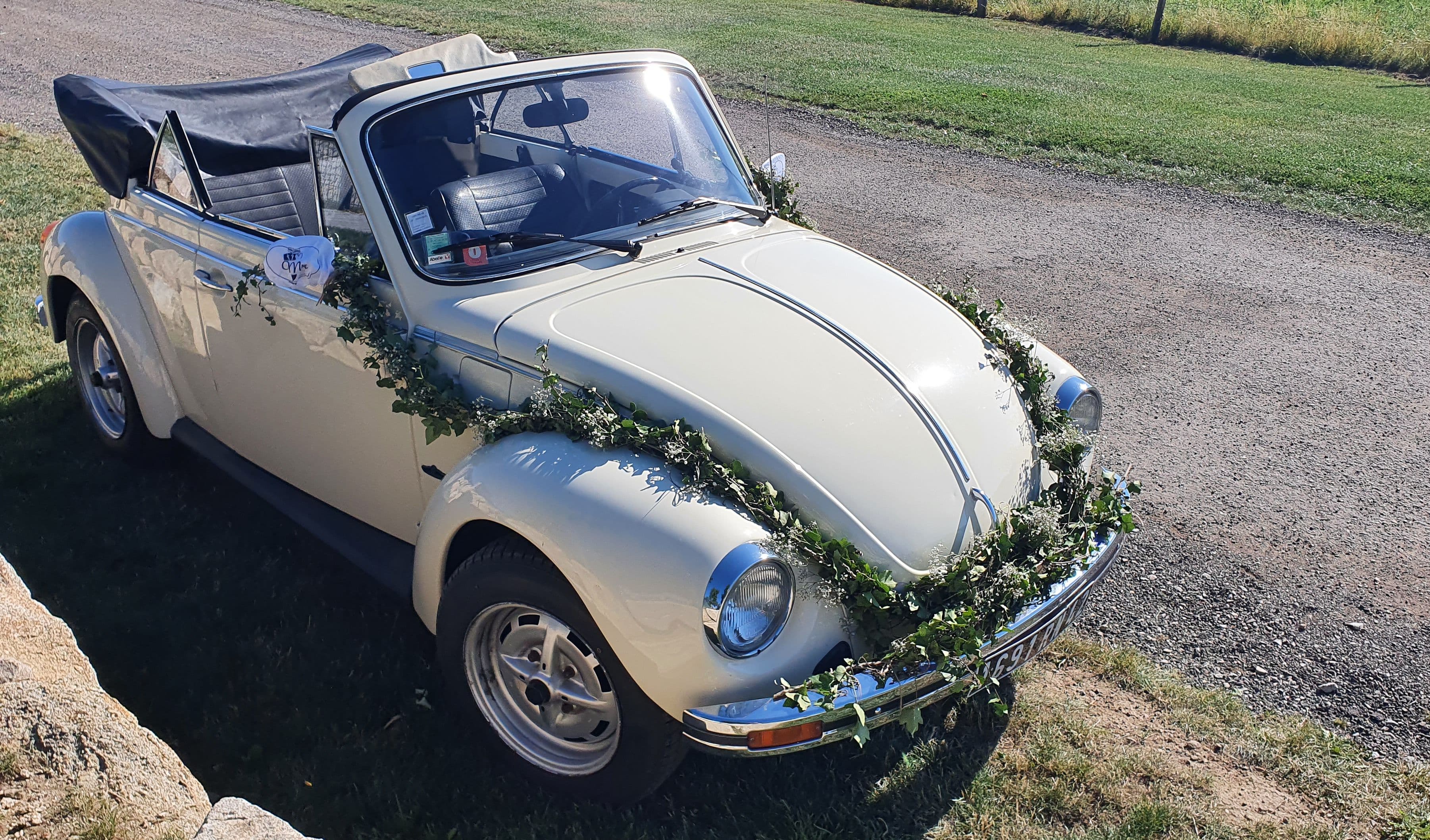 Une Citroën 2CV décapotable beige ornée de fleurs pour un mariage