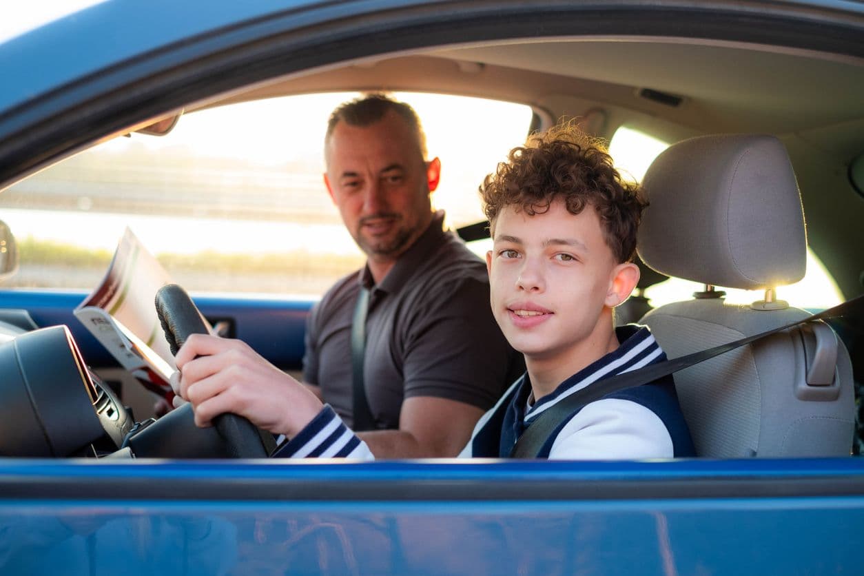Un jeune garçon au volant aux côtés de son accompagnateur. 