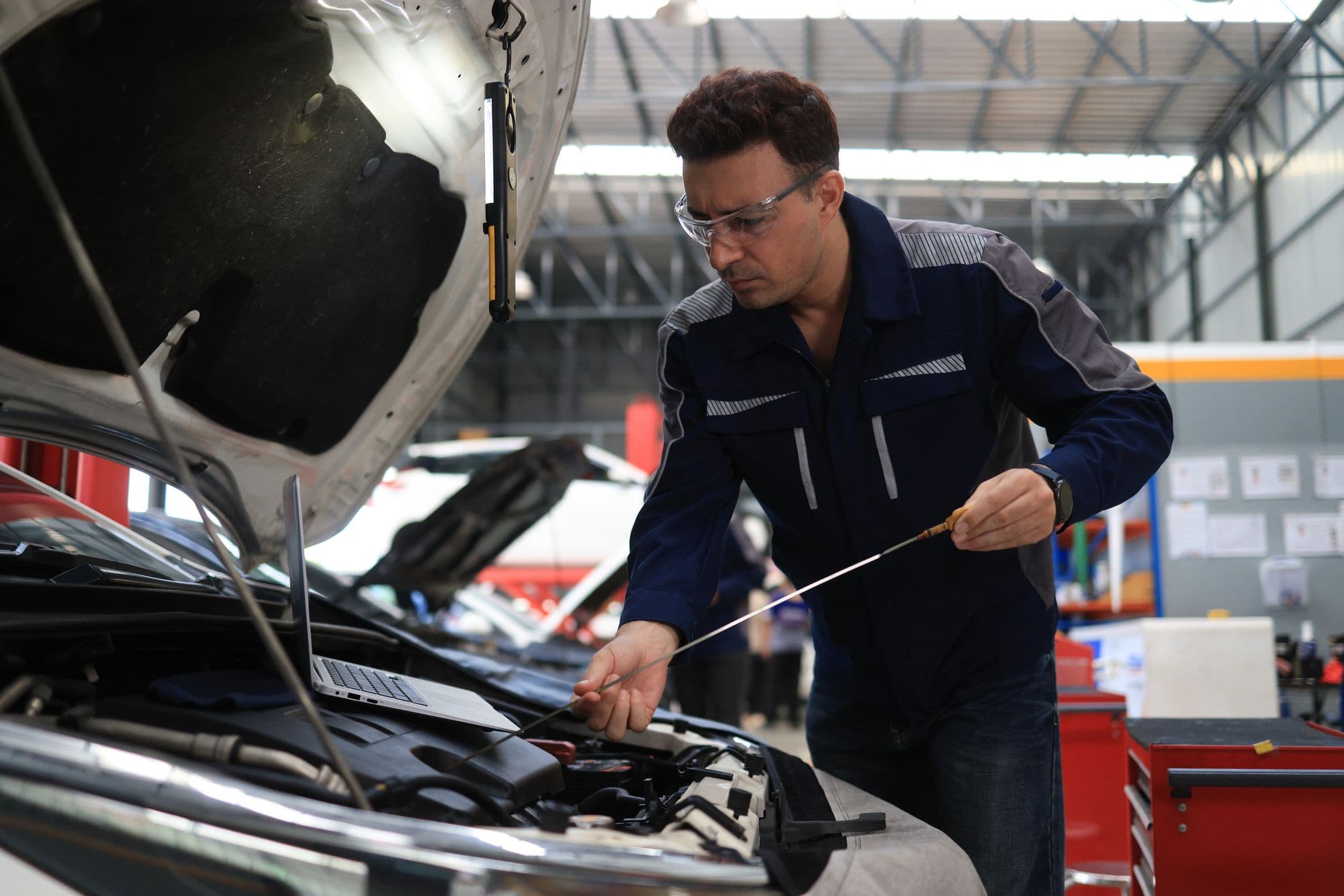 Technicien qui contrôle les liquides d'une voiture.