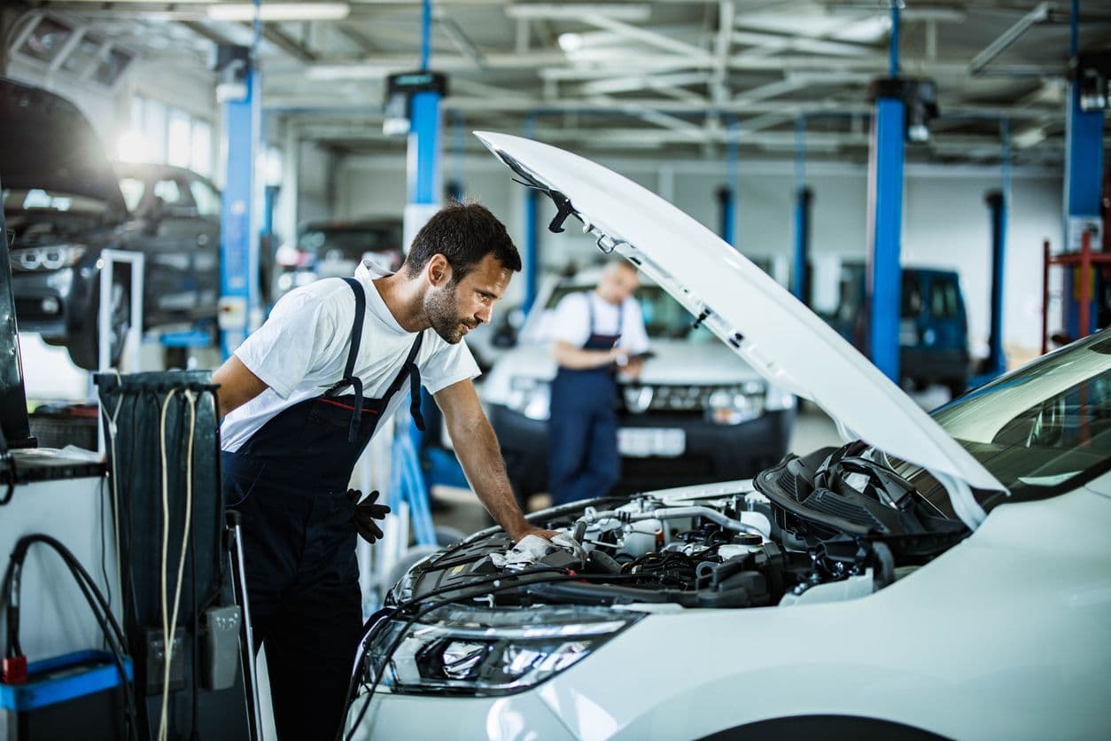 Technicien de contrôle technique contrôlant une voiture.