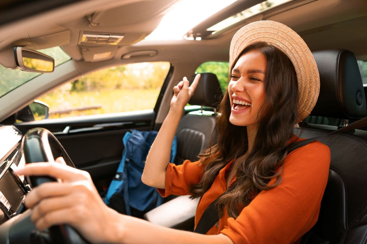 Une femme au volant chante.