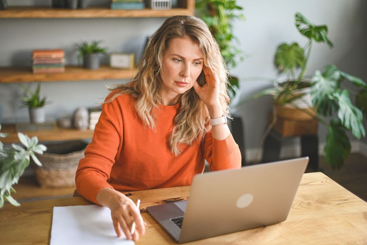 Une femme qui travaille sur son ordinateur à domicile.
