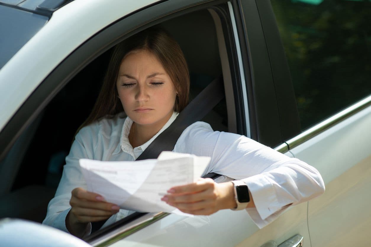 Une femme lisant un document dans une voiture.