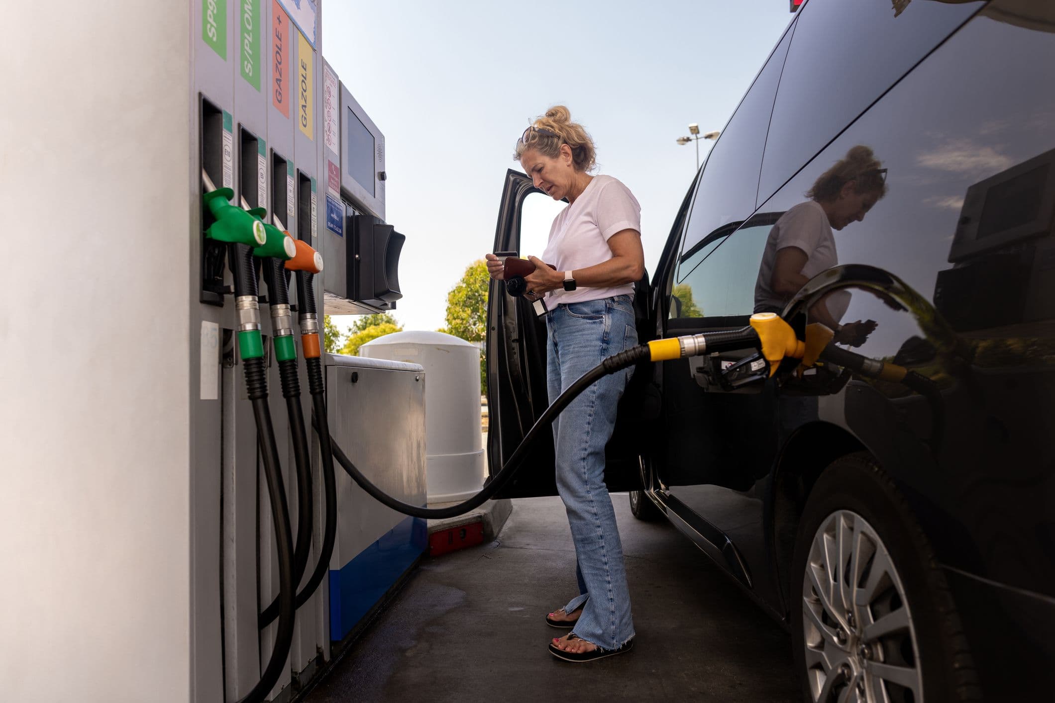 Une femme qui paye à la station-service.