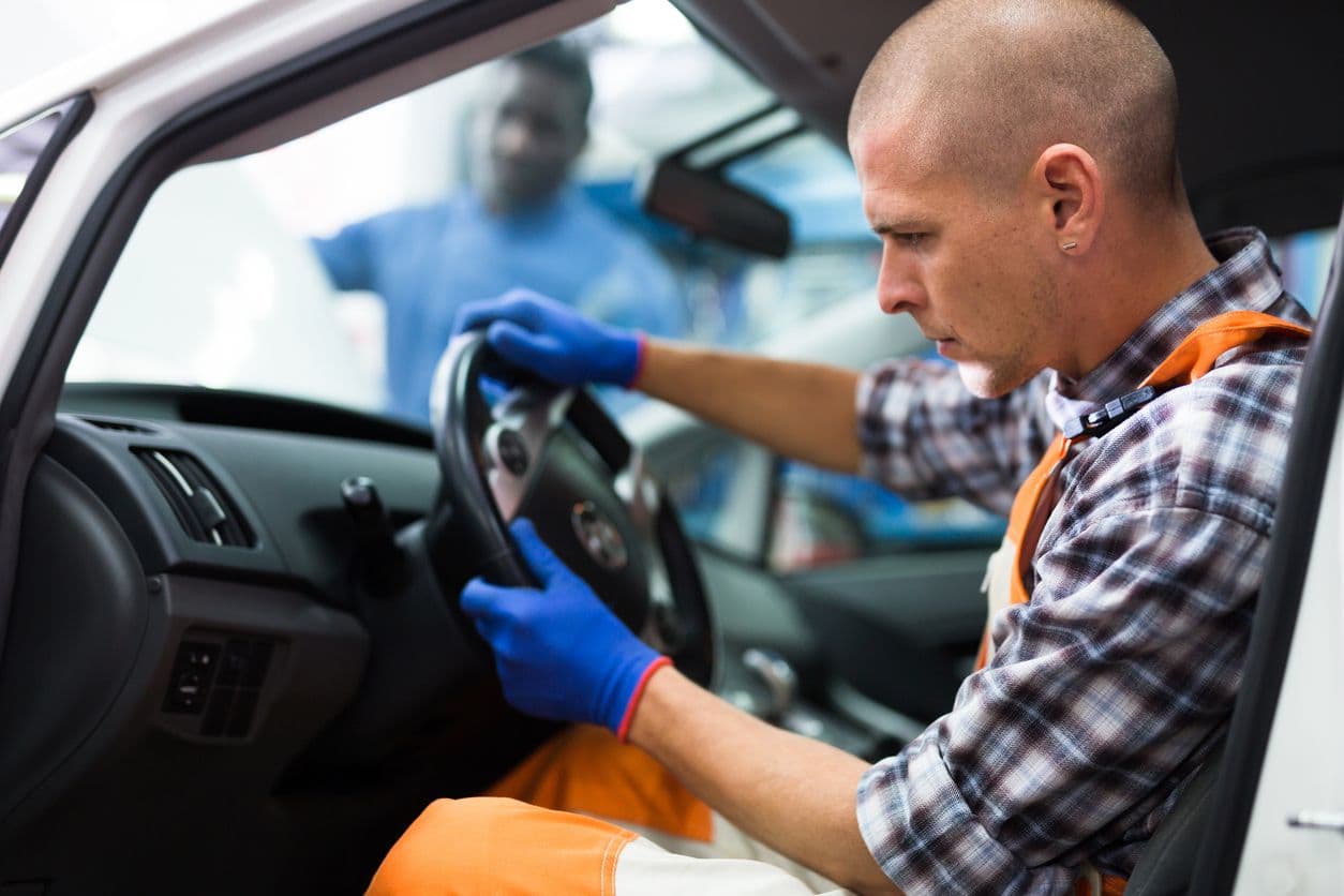 Un homme au volant d'une voiture pendant le contrôle technique.