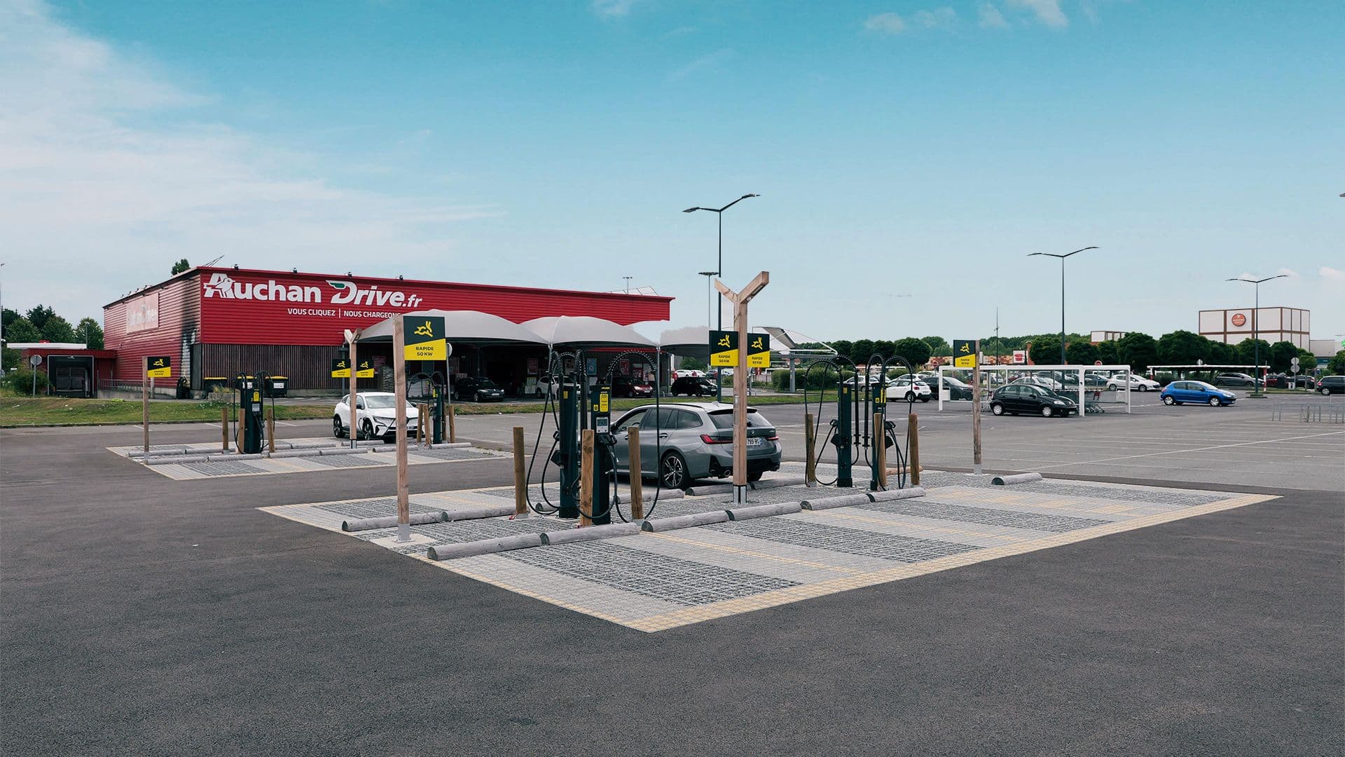 Bornes de recharge rapide Auchan Drive dans un parking avec voitures