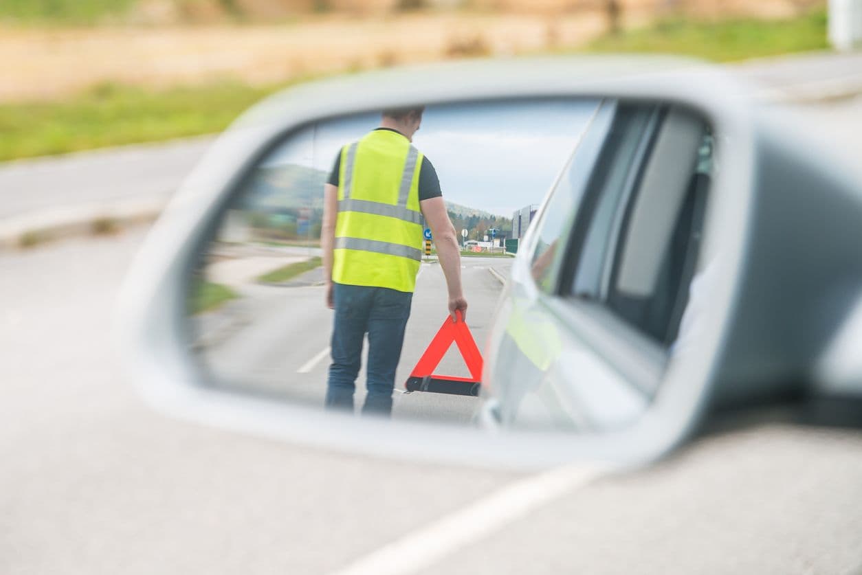 Un Gilet Réfléchissant Jaune Et Un Triangle De Signalisation Se Trouvent  Sur Le Capot De La Voiture Sécurité Sur La Route En Cas De Panne Ou D'arrêt  Sur L'autoroute