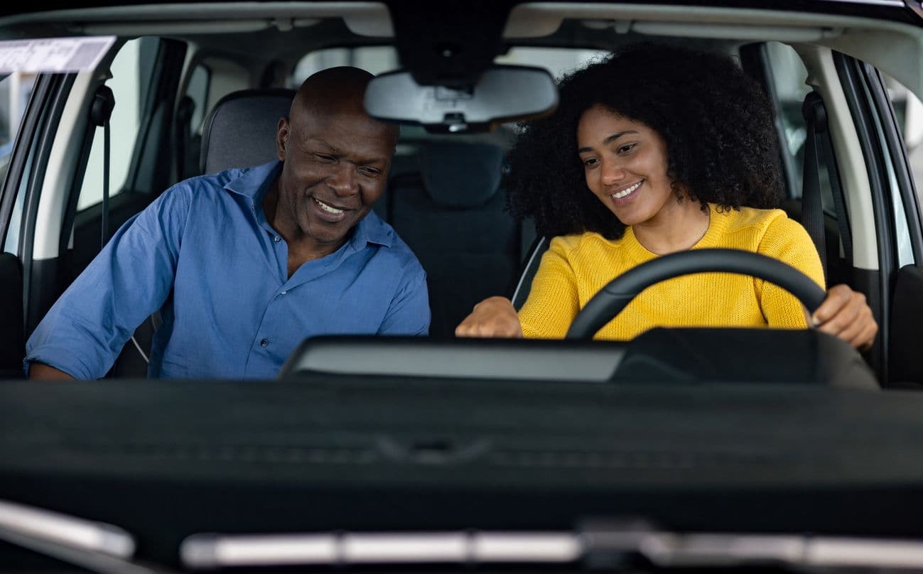 Un père et sa fille assis dans une voiture.
