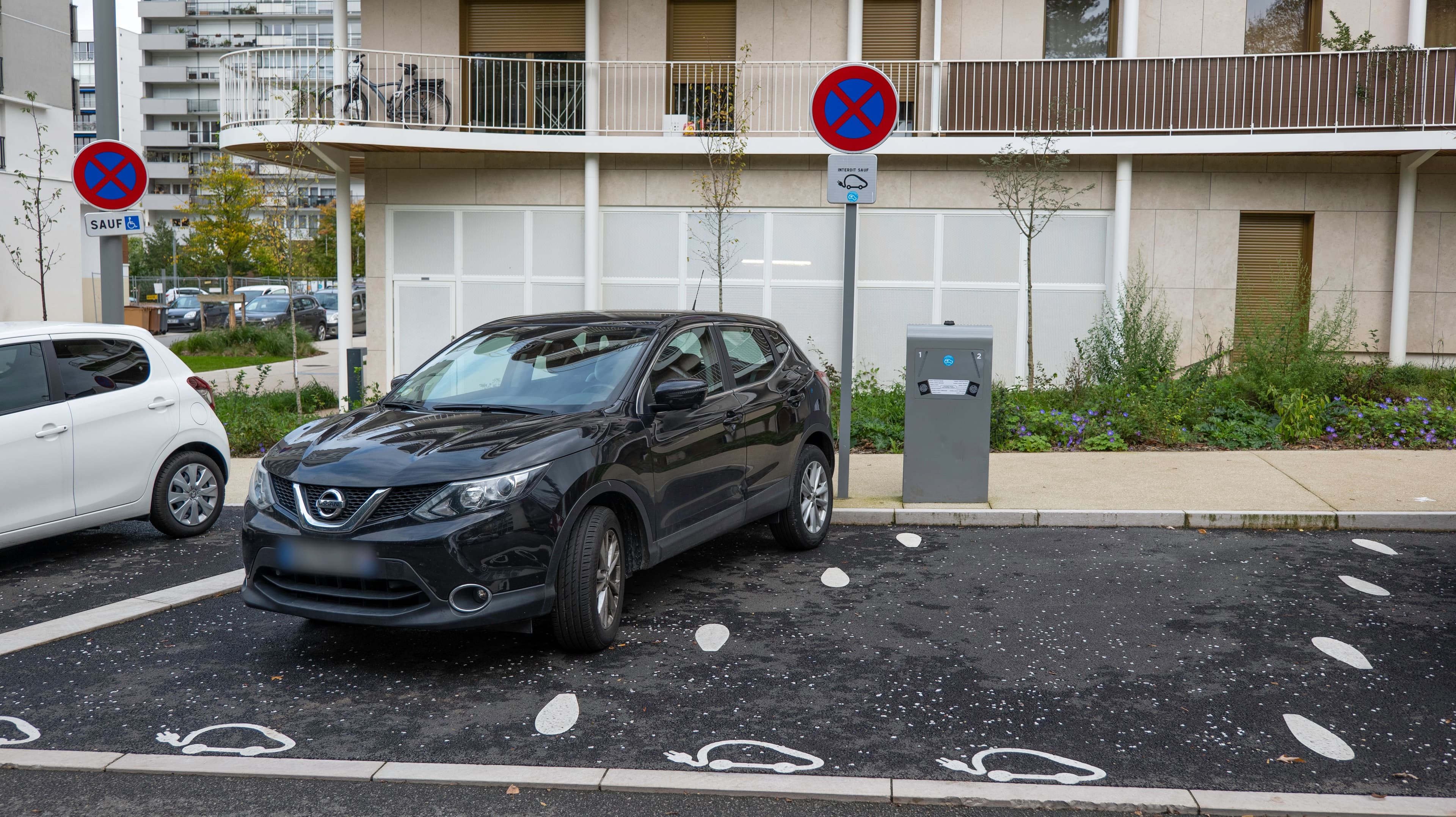 Une voiture thermique garée sur un emplacement pour recharge électrique.