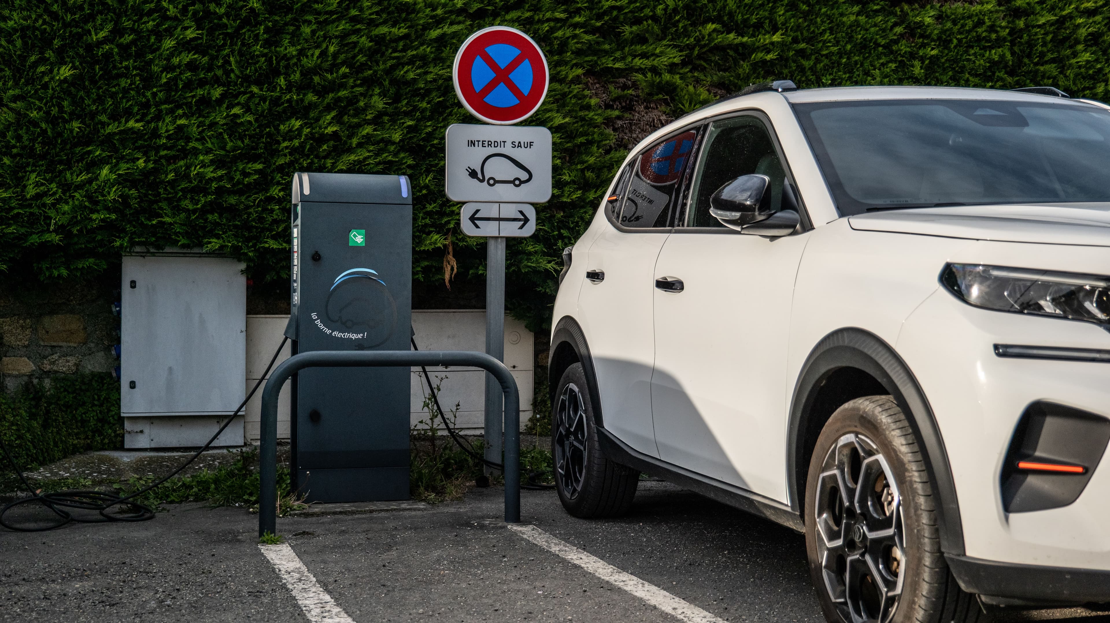 Une voiture électrique blanche en train de se recharger