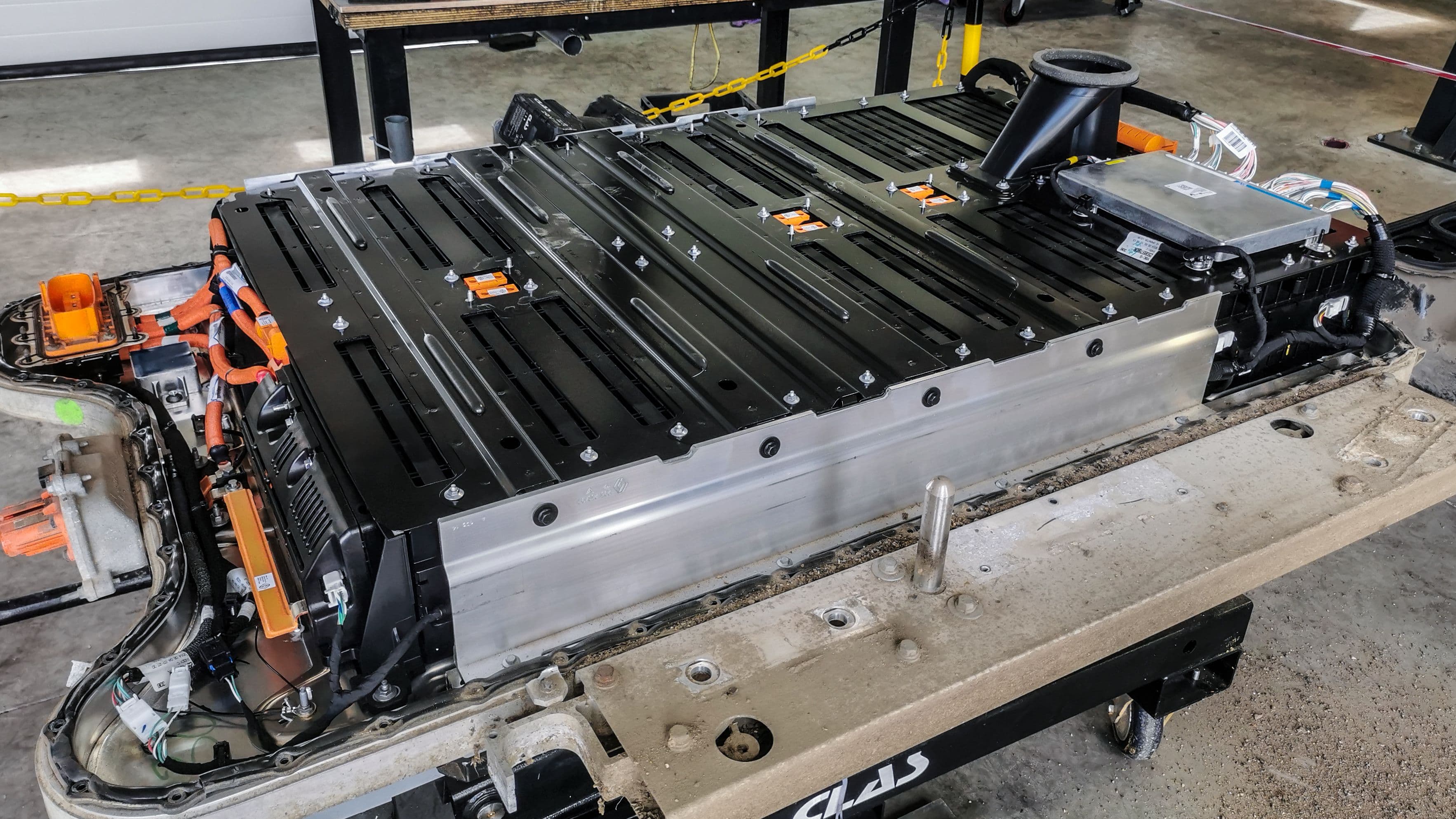 Un pack batterie de voiture électrique démonté, dans un garage