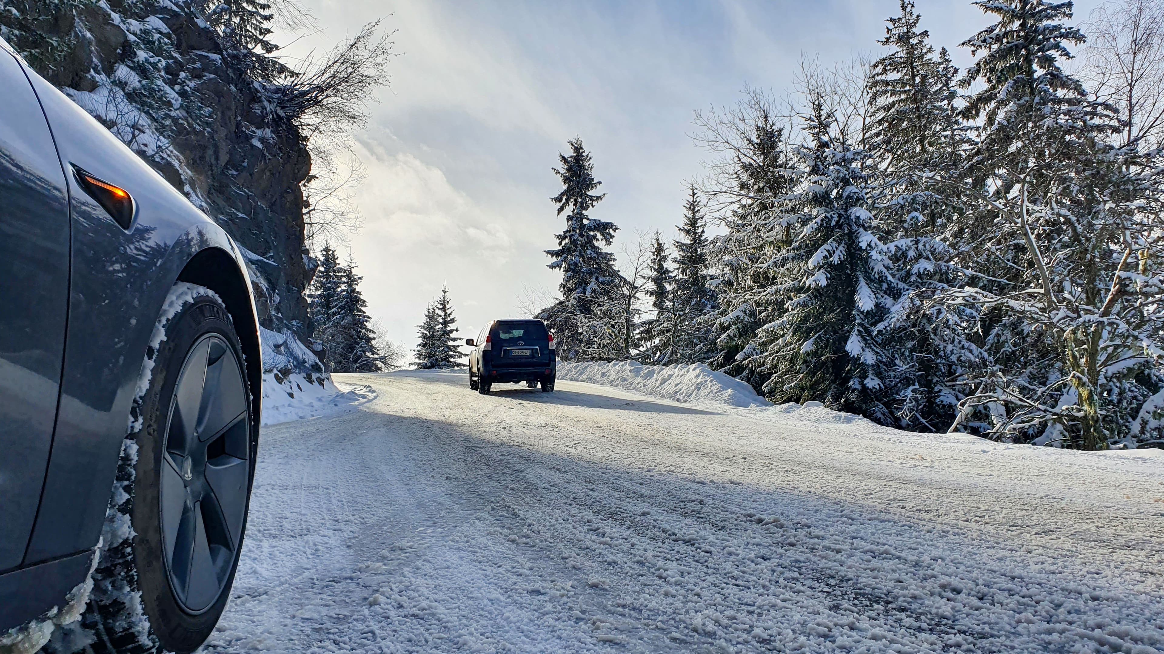 Zoom sur un pneu hiver sur une route de montagne enneigée
