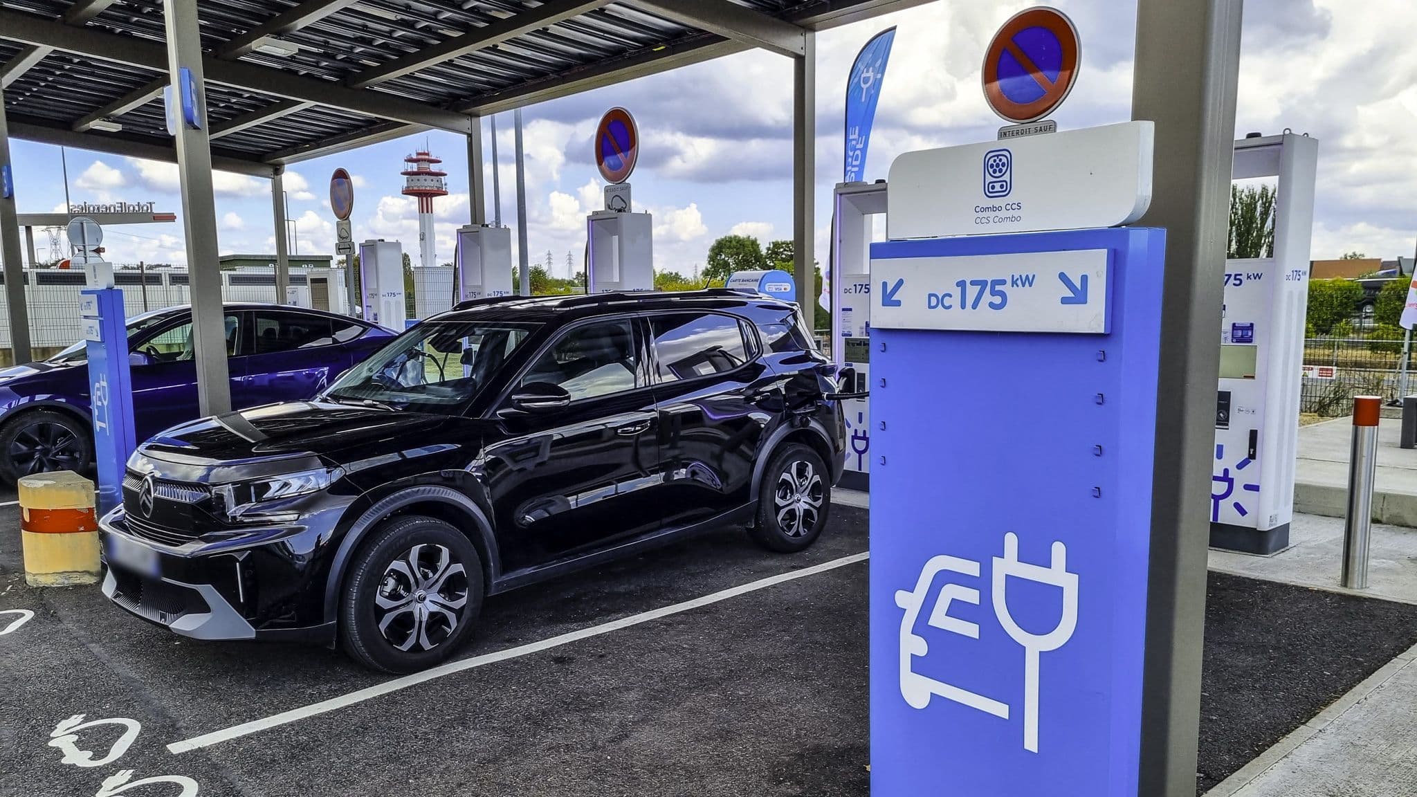 Une voiture électrique en cours de recharge sur l'autoroute.