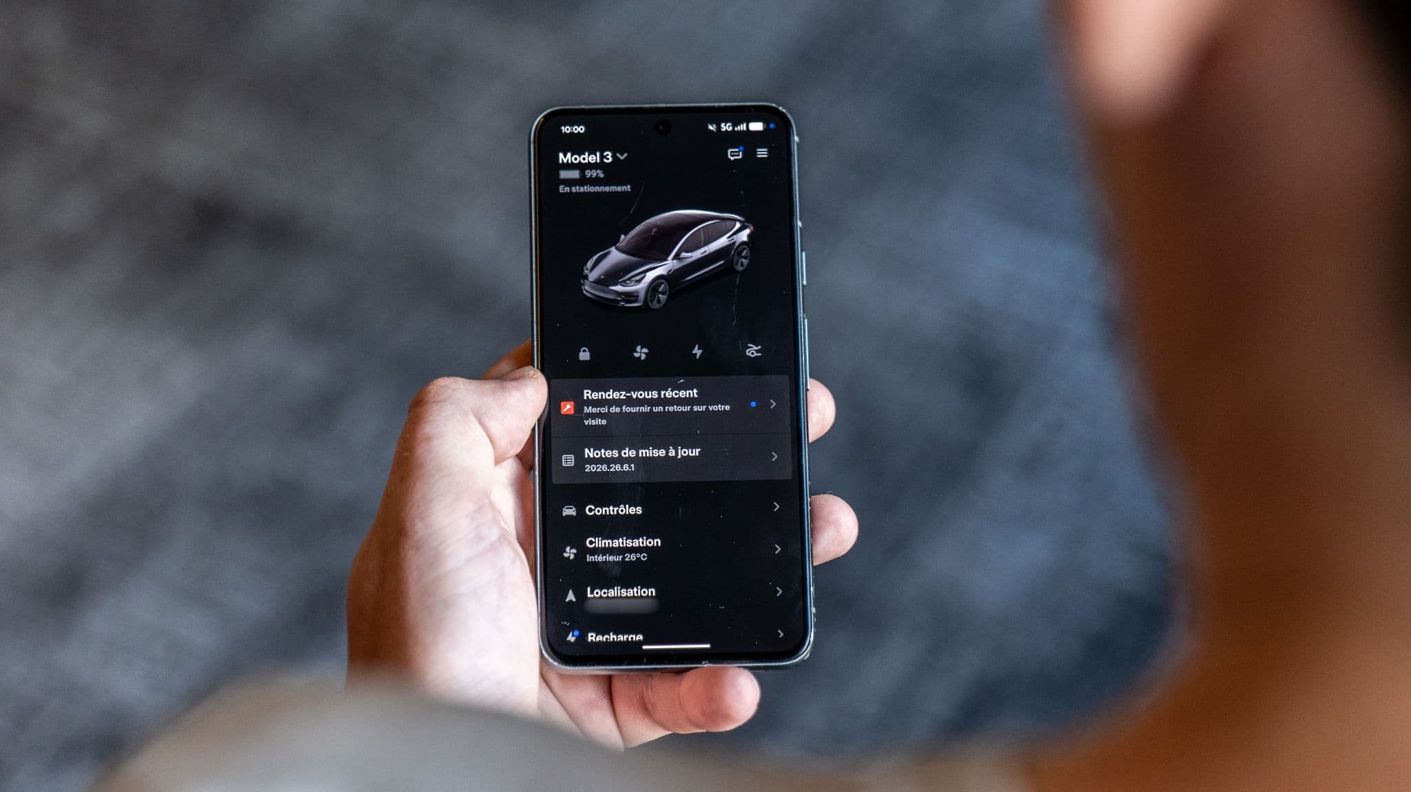 Une personne consulte son application Tesla depuis son smartphone. ©Roole