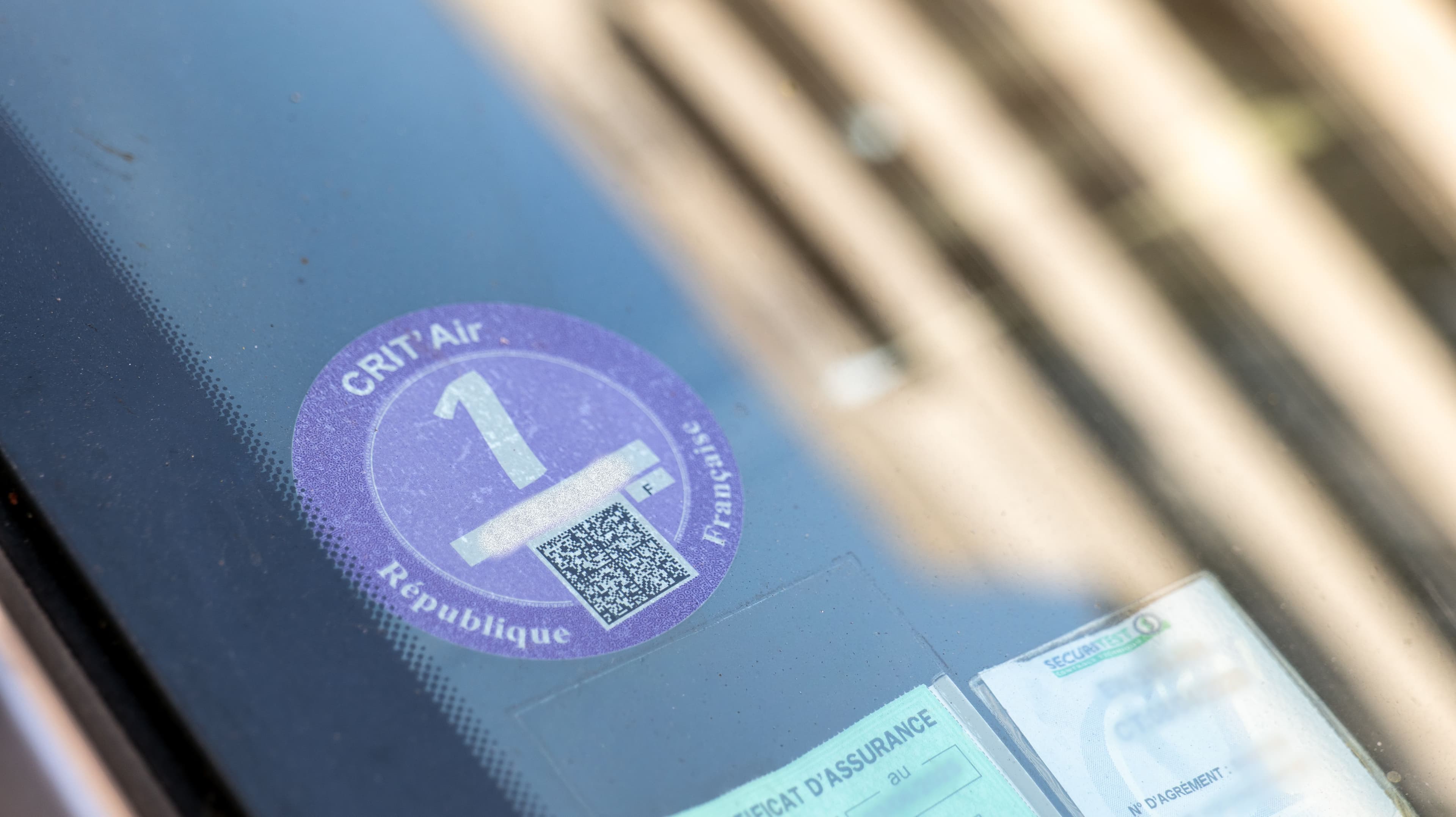 Une vignette Crit'Air 1 apposée sur un pare-brise
