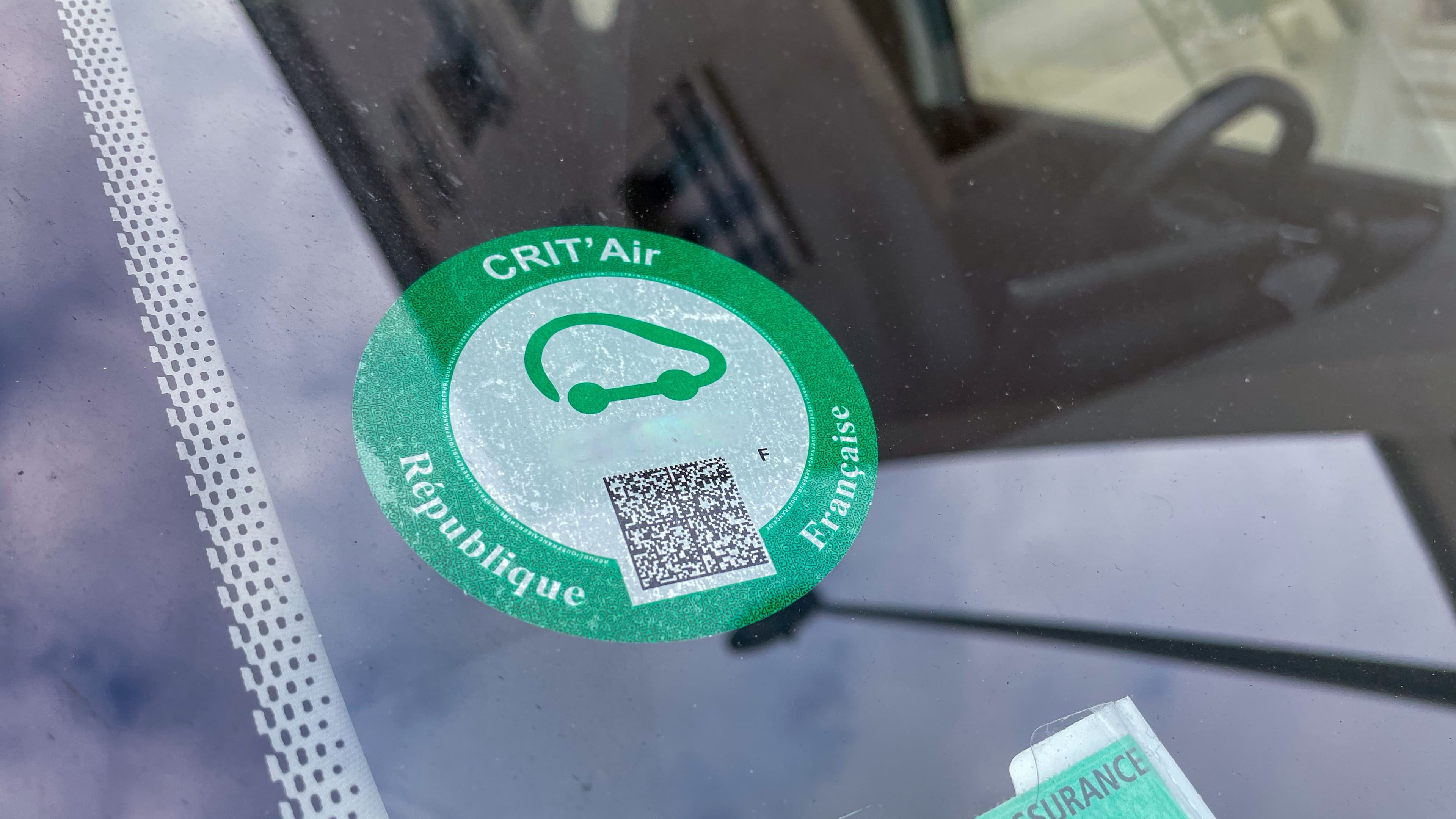 une vignette crit'air verte apposée sur un parebrise de voiture