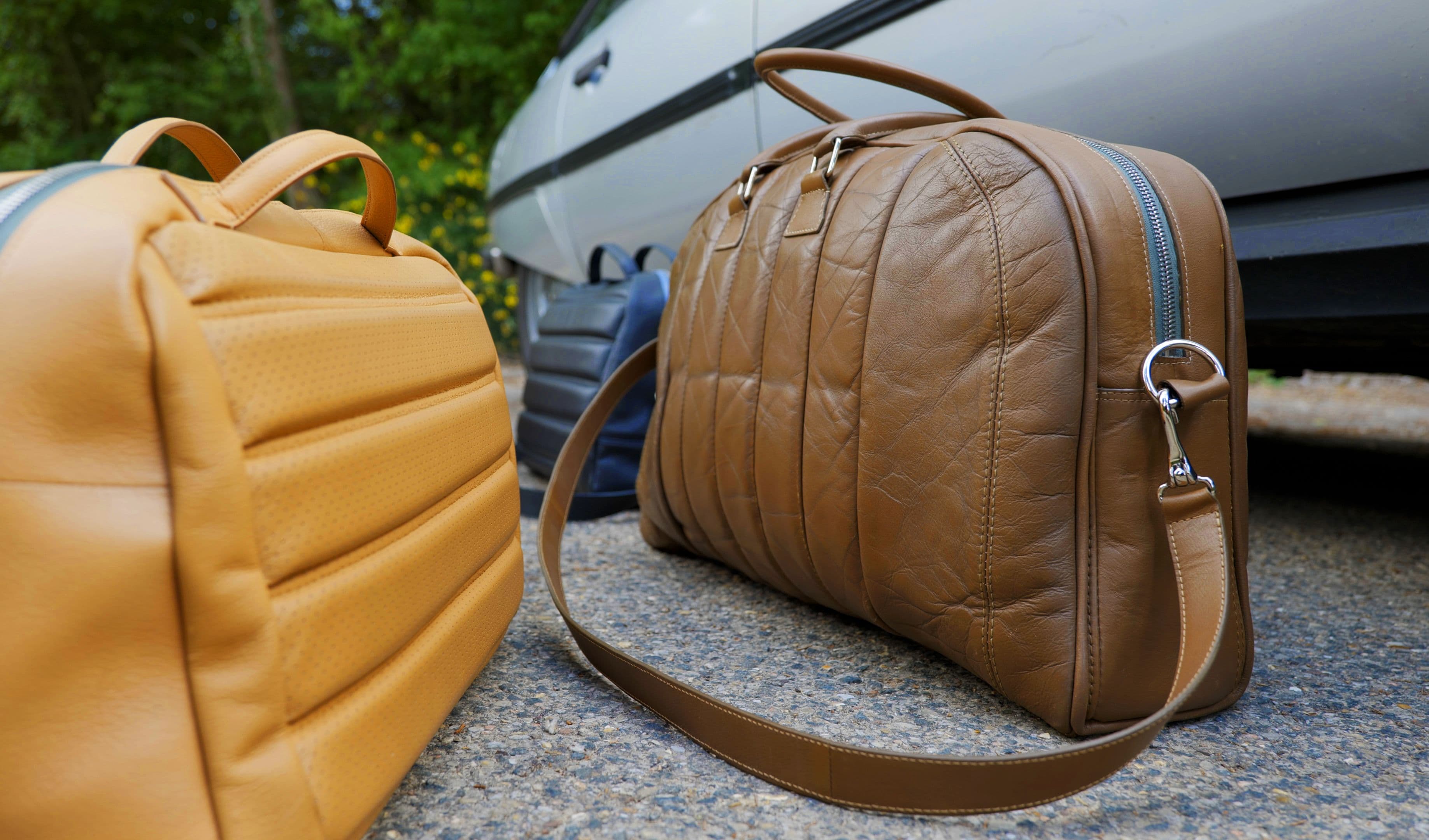 Des sacs et bagages upcyclés par Mileage devant une voiture de collection