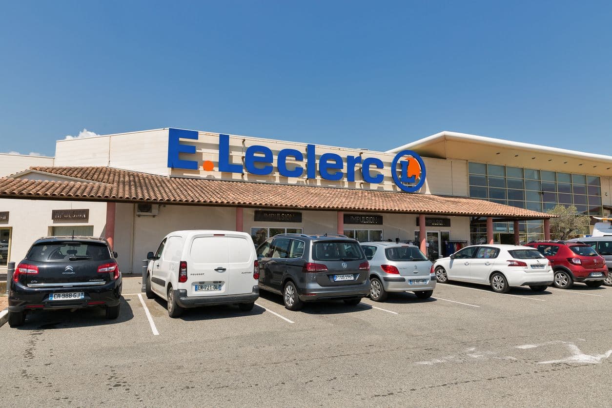 Une station e-leclerc avec des voitures garées devant.