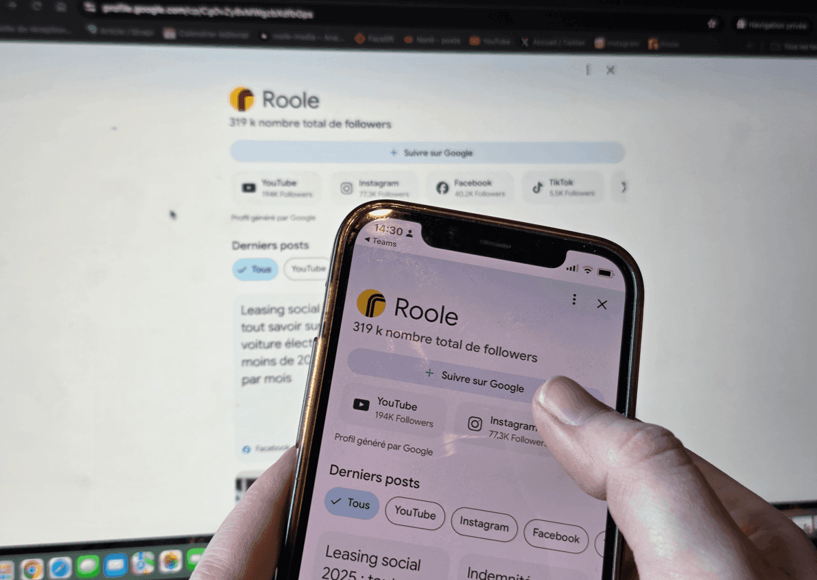 Gros plan sur un téléphone portable sur la page google de Roole, quelqu'un s'apprête à suivre la page. En fond, la même page Google ouverte sur un ordinateur.