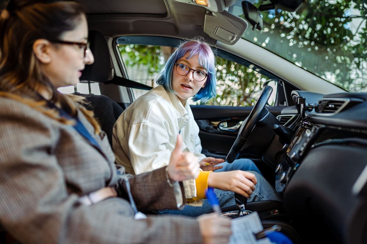 Une élève assise côté conducteur en apprentissage à l'auto-école.