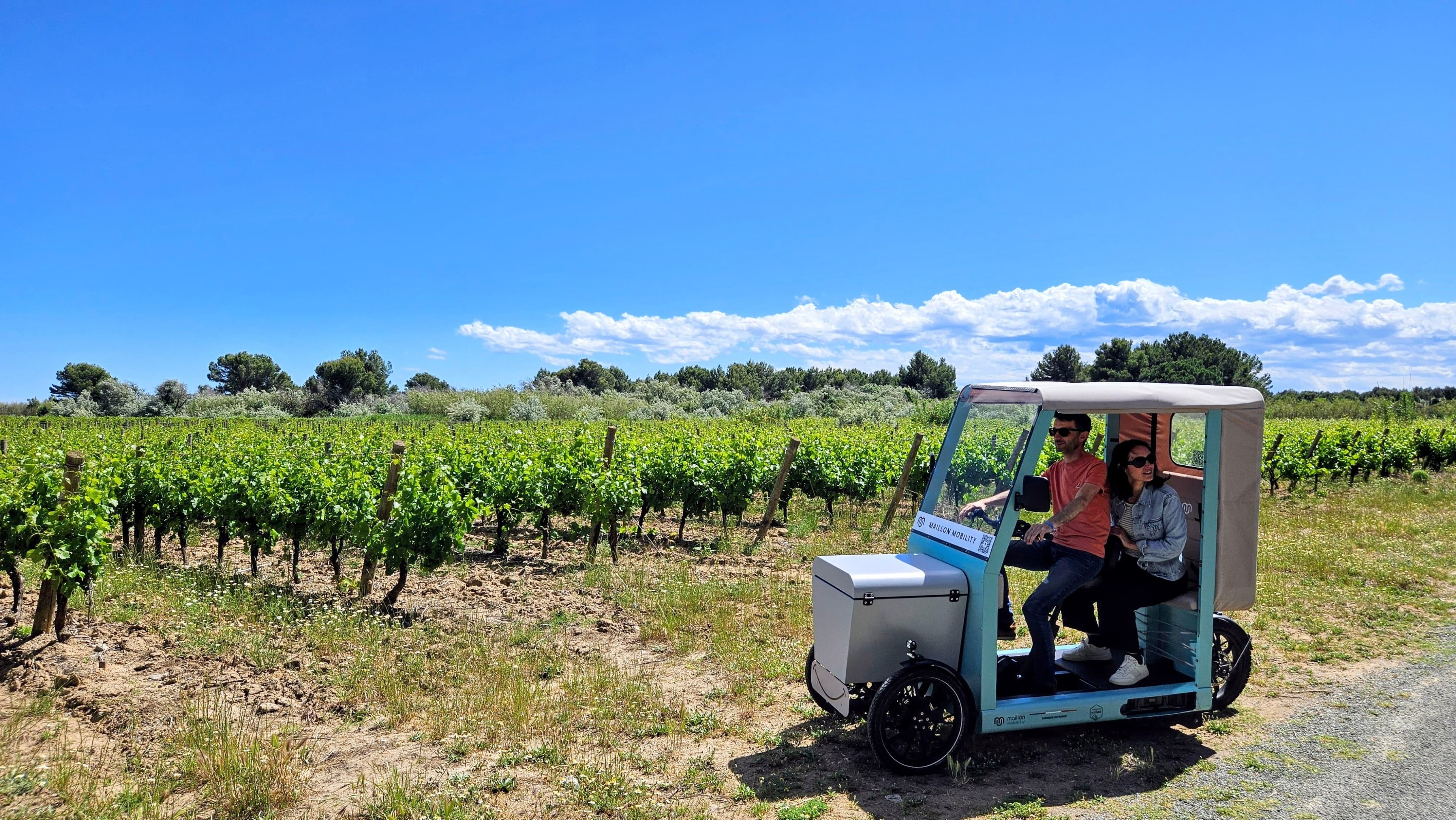 véhicule intermédiaire électrique avec deux passagers dans une vigne ensoleillée