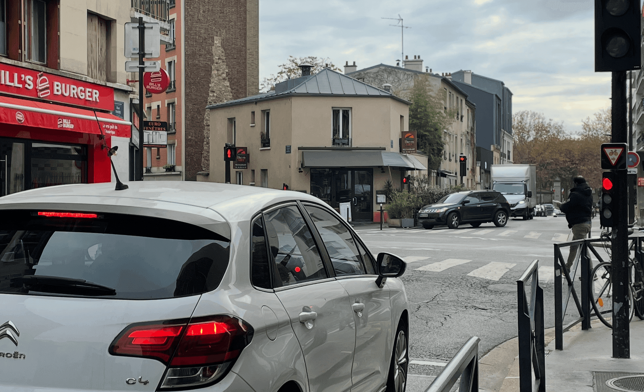 Une voiture blanche garée à un feu.