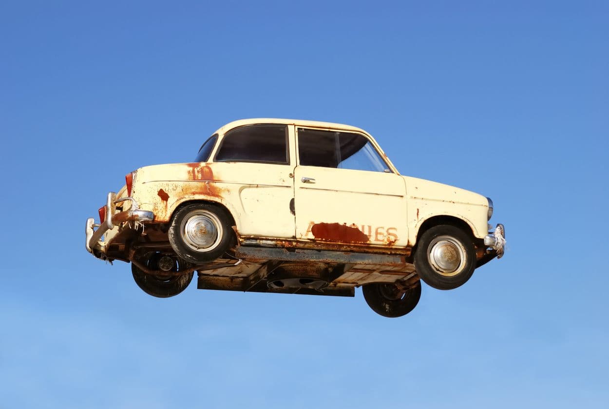 Une ancienne voiture qui vole dans les airs.