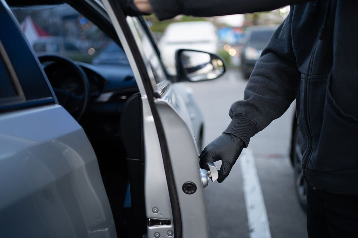 Un homme s'introduit dans une voiture pour la voler.