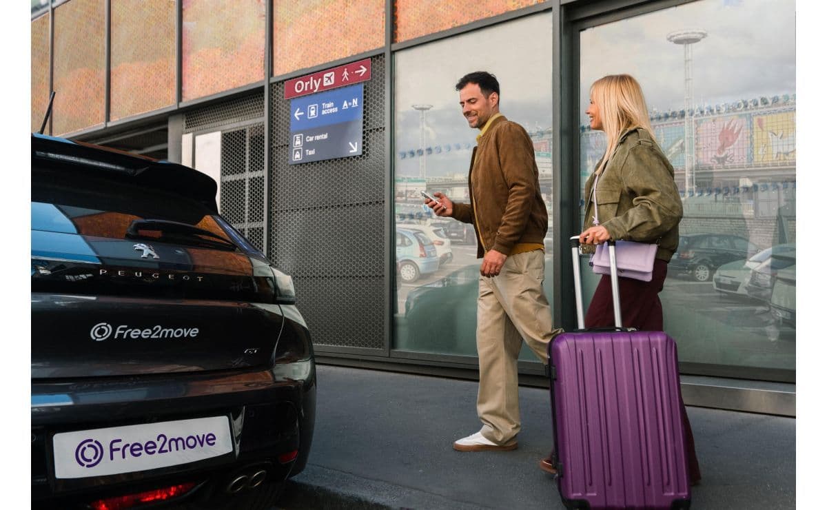 Une voiture Peugeot Free2move devant un panneau des terminaux de l'aéroport d'Orly. 