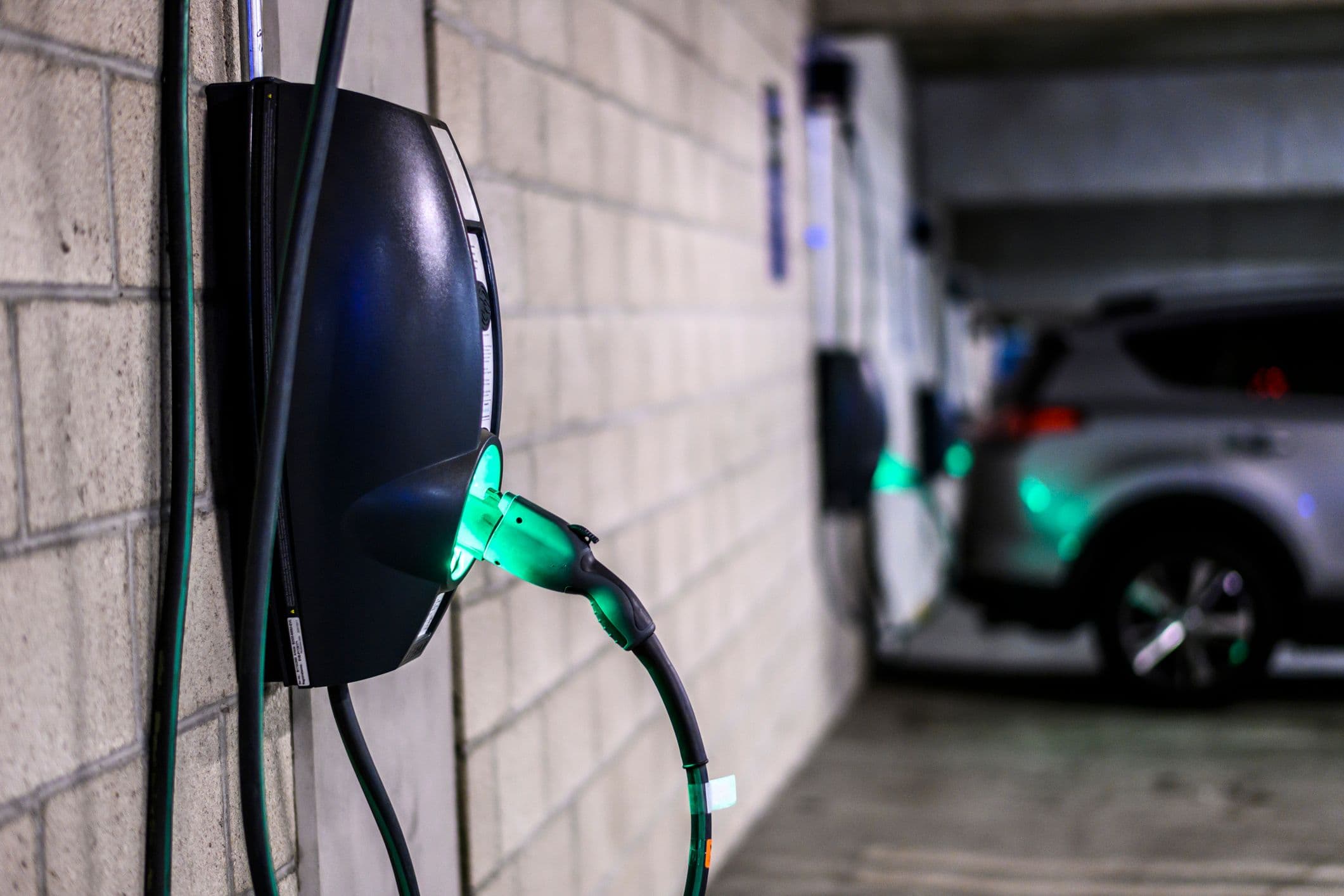 Une borne de recharge électrique murale dans un parking privé