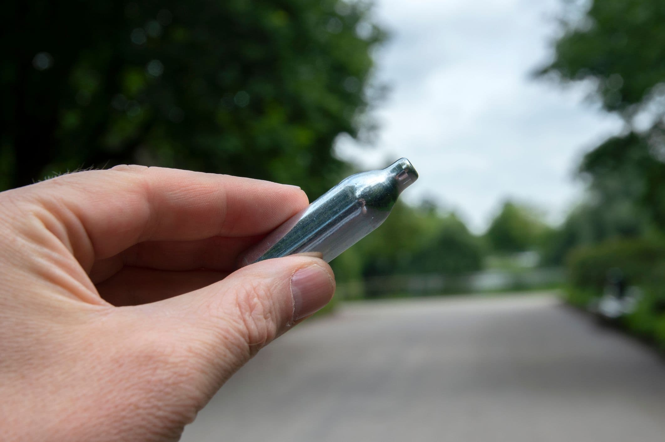 Une main qui tient un cartouche de protoxyde d'azote après un contrôle sur une route