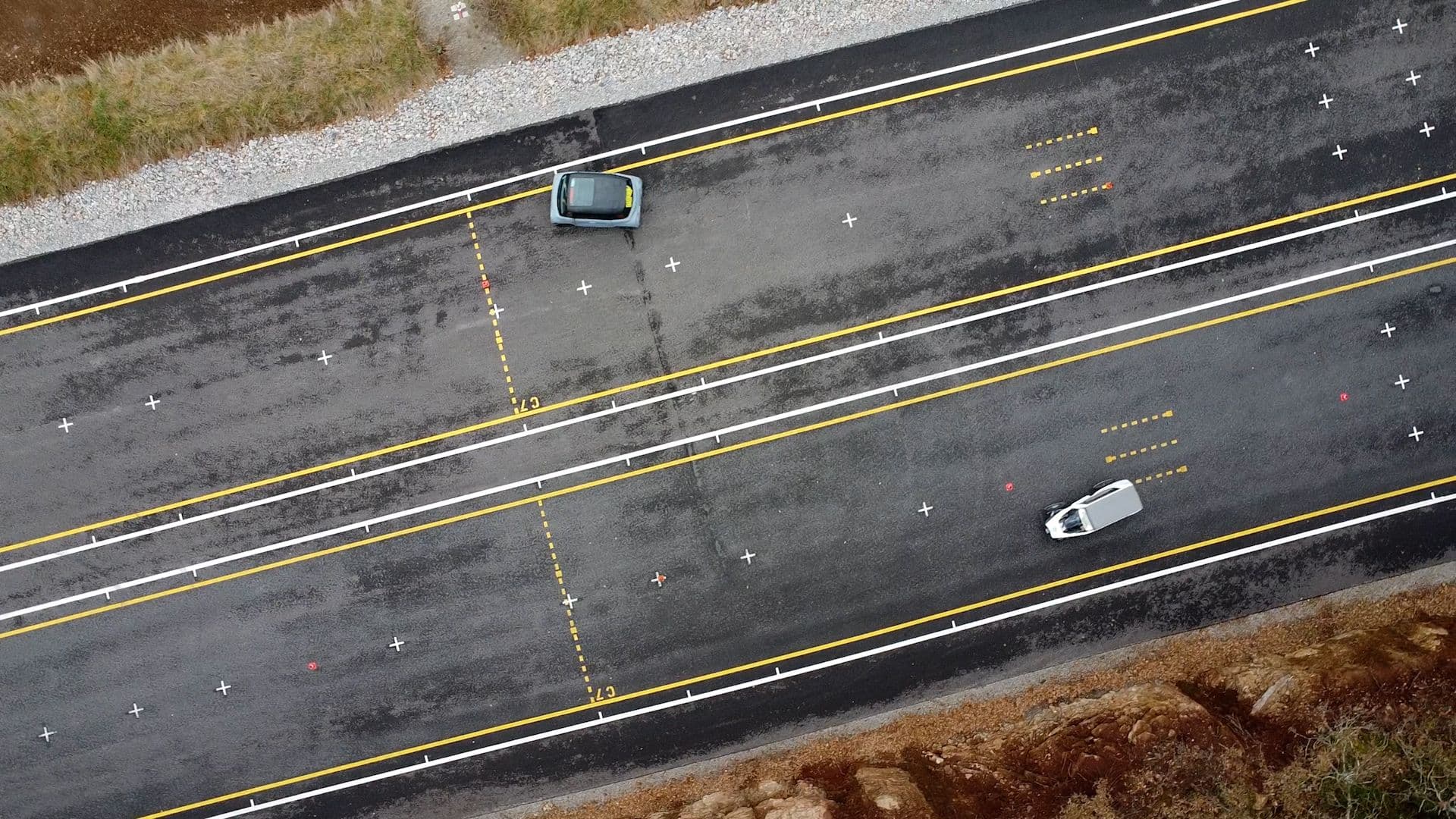 Vue drone au dessus de deux véhicules intermédiaires qui roulent sur une piste d'essai d'auto école