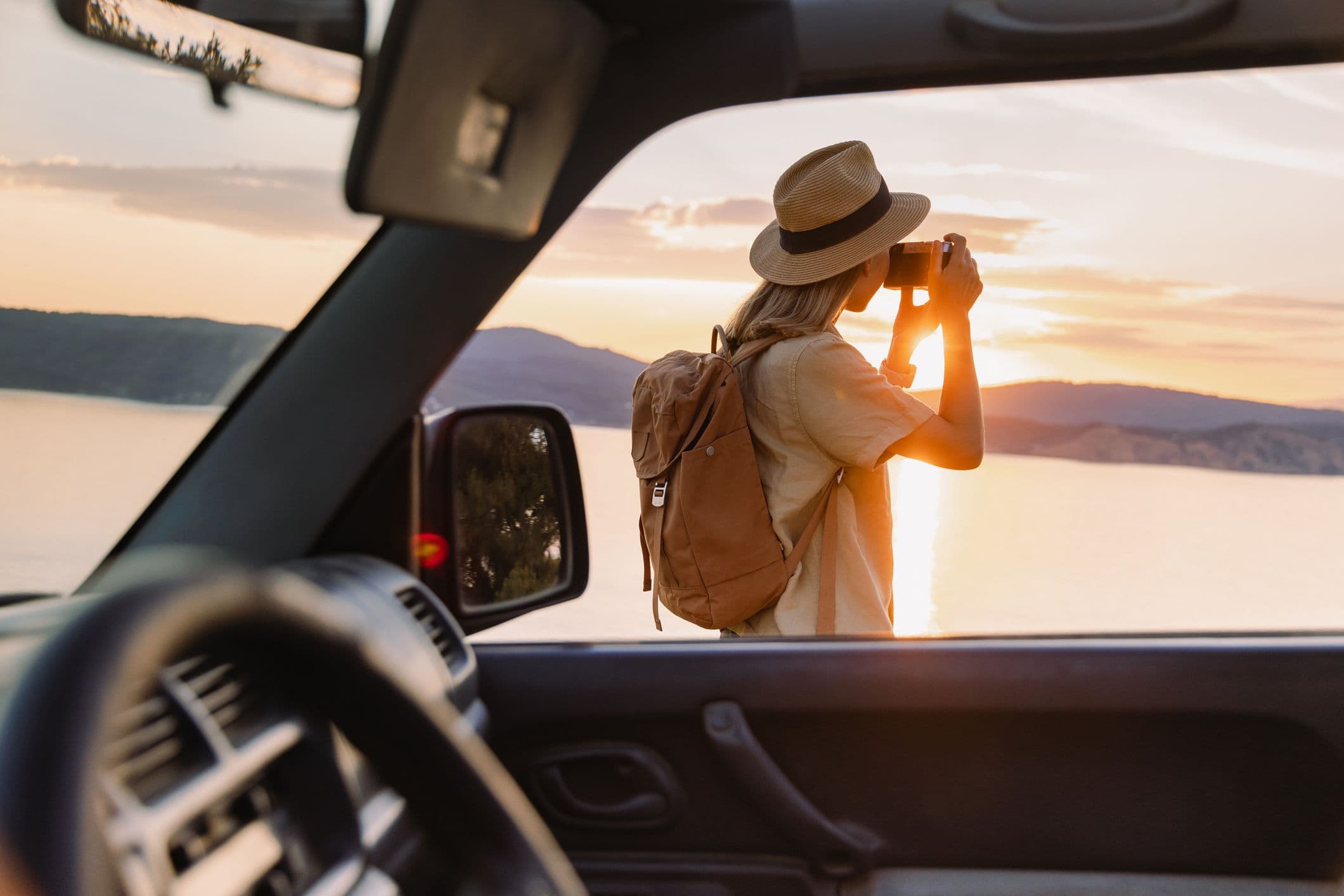 Une femme descendue de sa voiture en stationnement pour prendre une photo