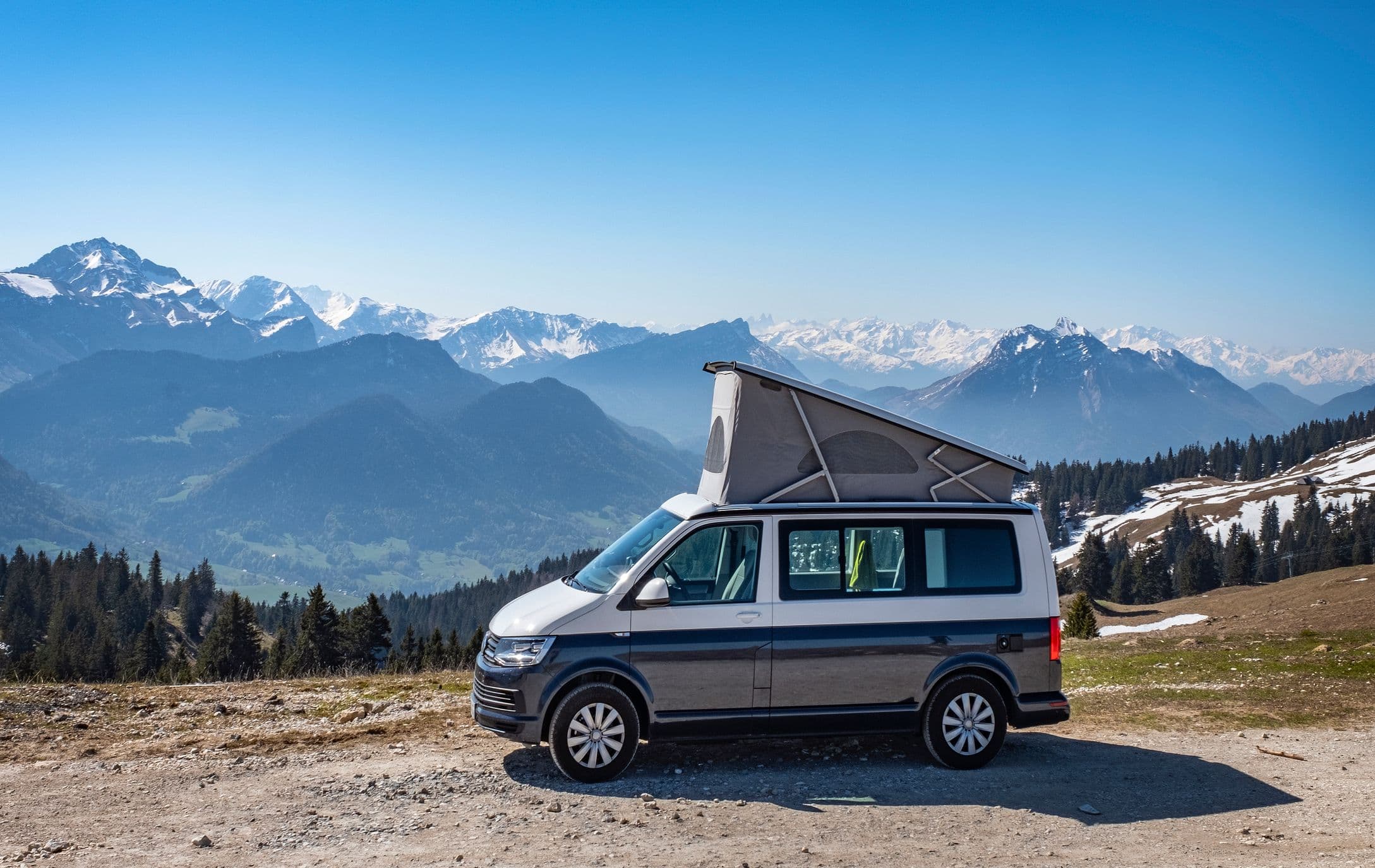 Van aménagé stationné face à un paysage de montagne spectaculaire, symbole de liberté et de voyage en pleine nature
