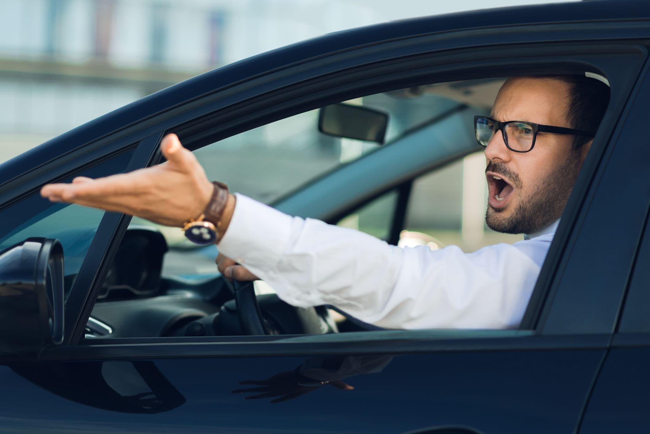 Un automobiliste mécontent qui râle par la fenêtre de sa voiture