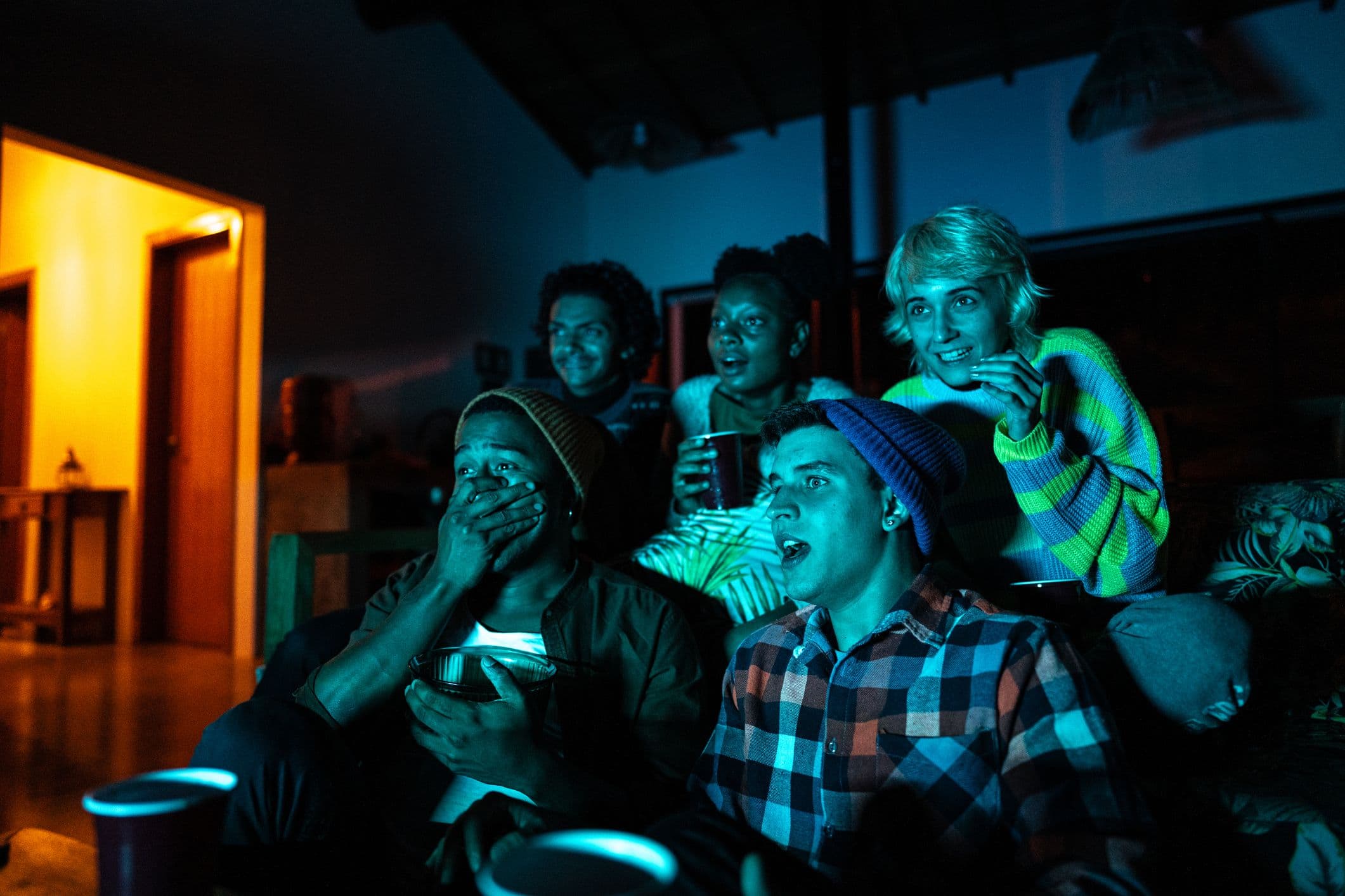 Une photo d'un groupe d'amis regardant un film ensemble pour illustrer notre quiz sur les voitures connues dans les blockbusters du cinéma