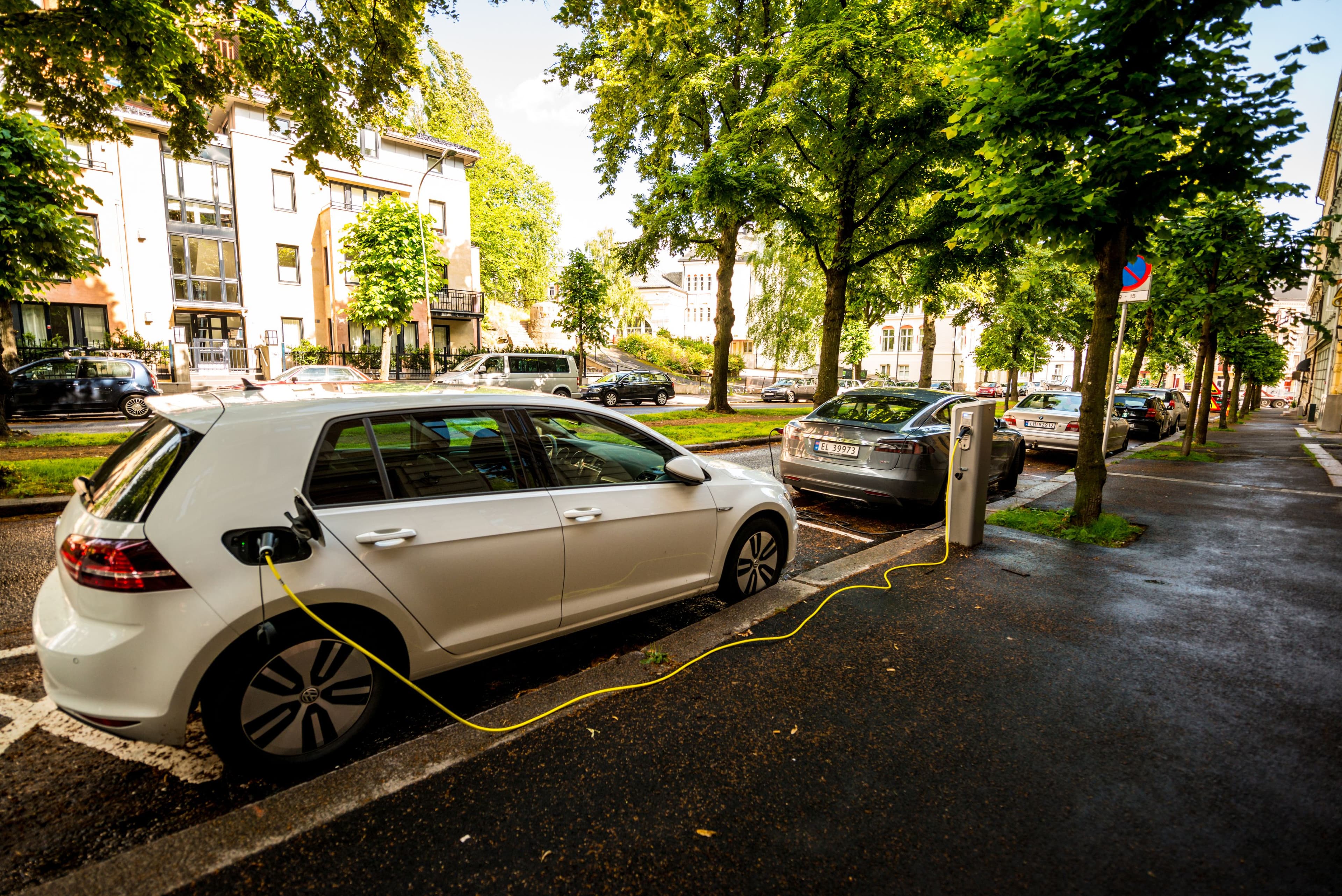 Une voiture électrique charge sur une borne de recharge, dans une rue d'Oslo.
