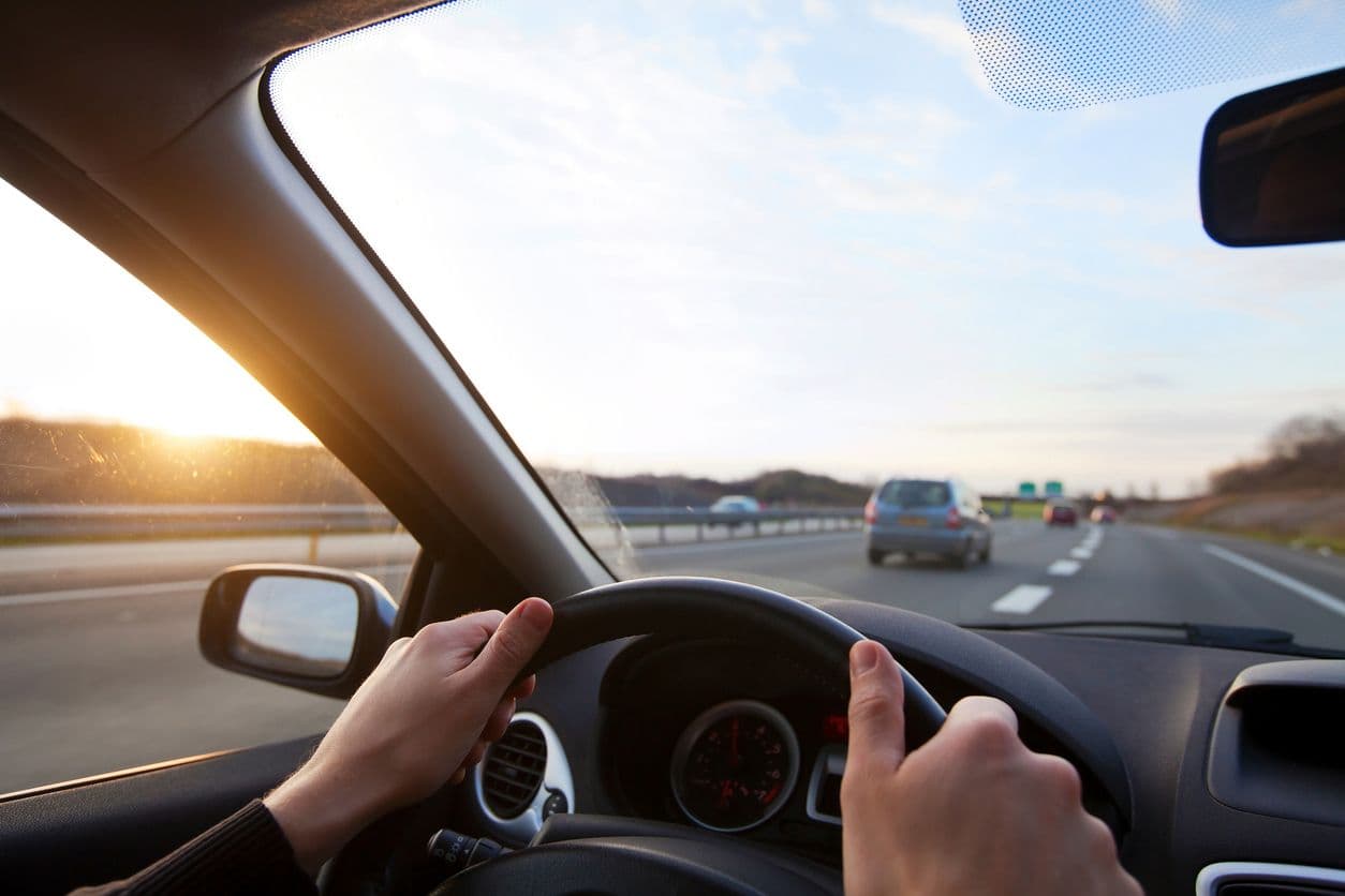 des mains sur un volant de voiture