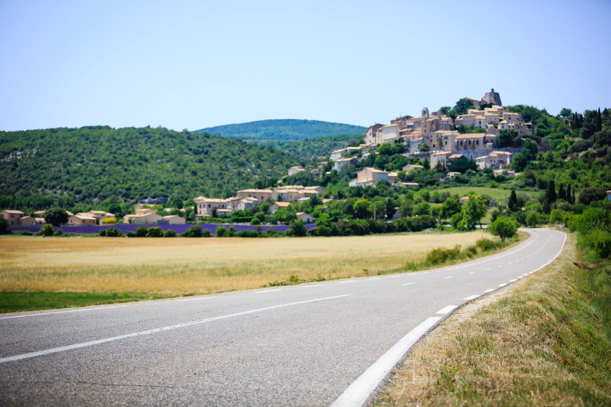 Une route qui mène vers un village verdoyant en hauteur