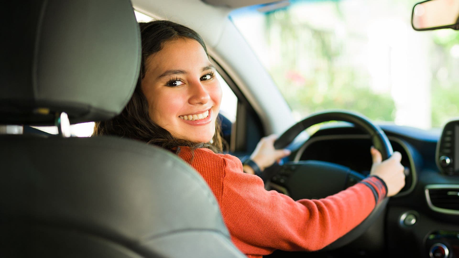 Une jeune conductrice au volant de sa première voiture pour illustrer le choix des véhicules les plus choisis par les jeunes conducteurs