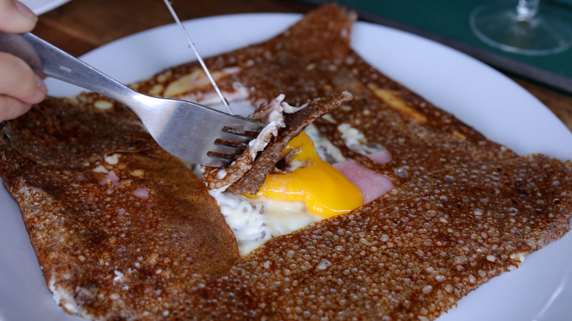 En pleine dégustation d’une galette gourmande avec un œuf coulant. ©Roole
