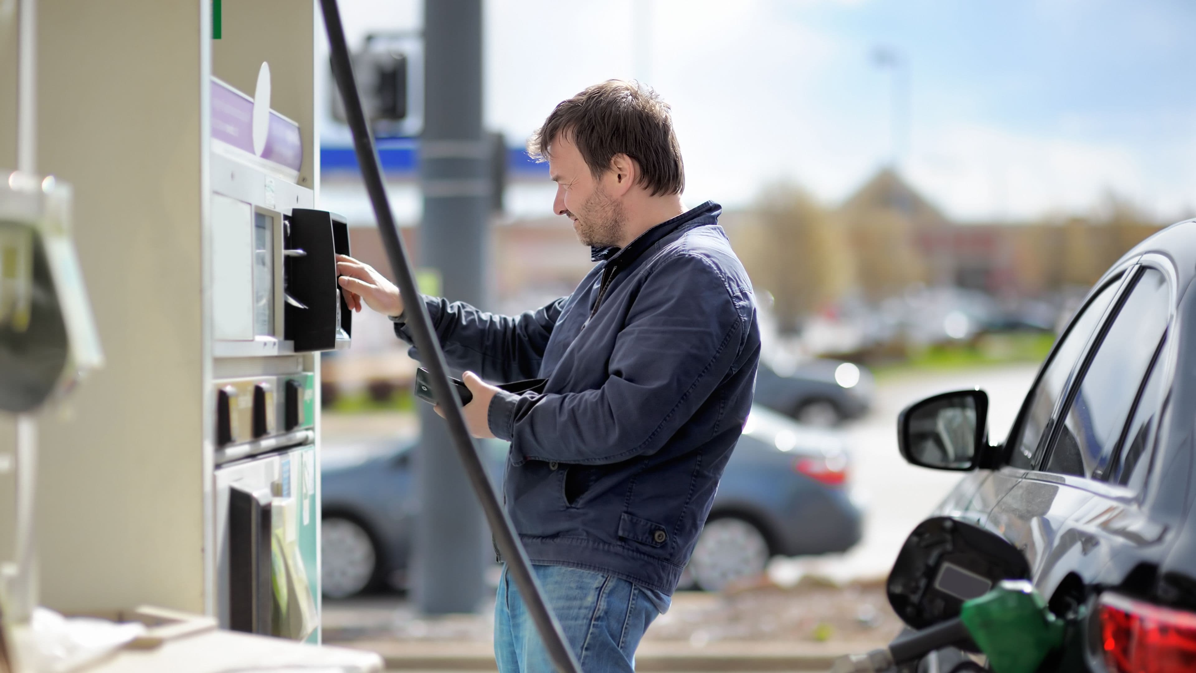Un homme qui paie son carburant à la station-service pour mettre en avant notre quiz sur les meilleures manières de faire des économies