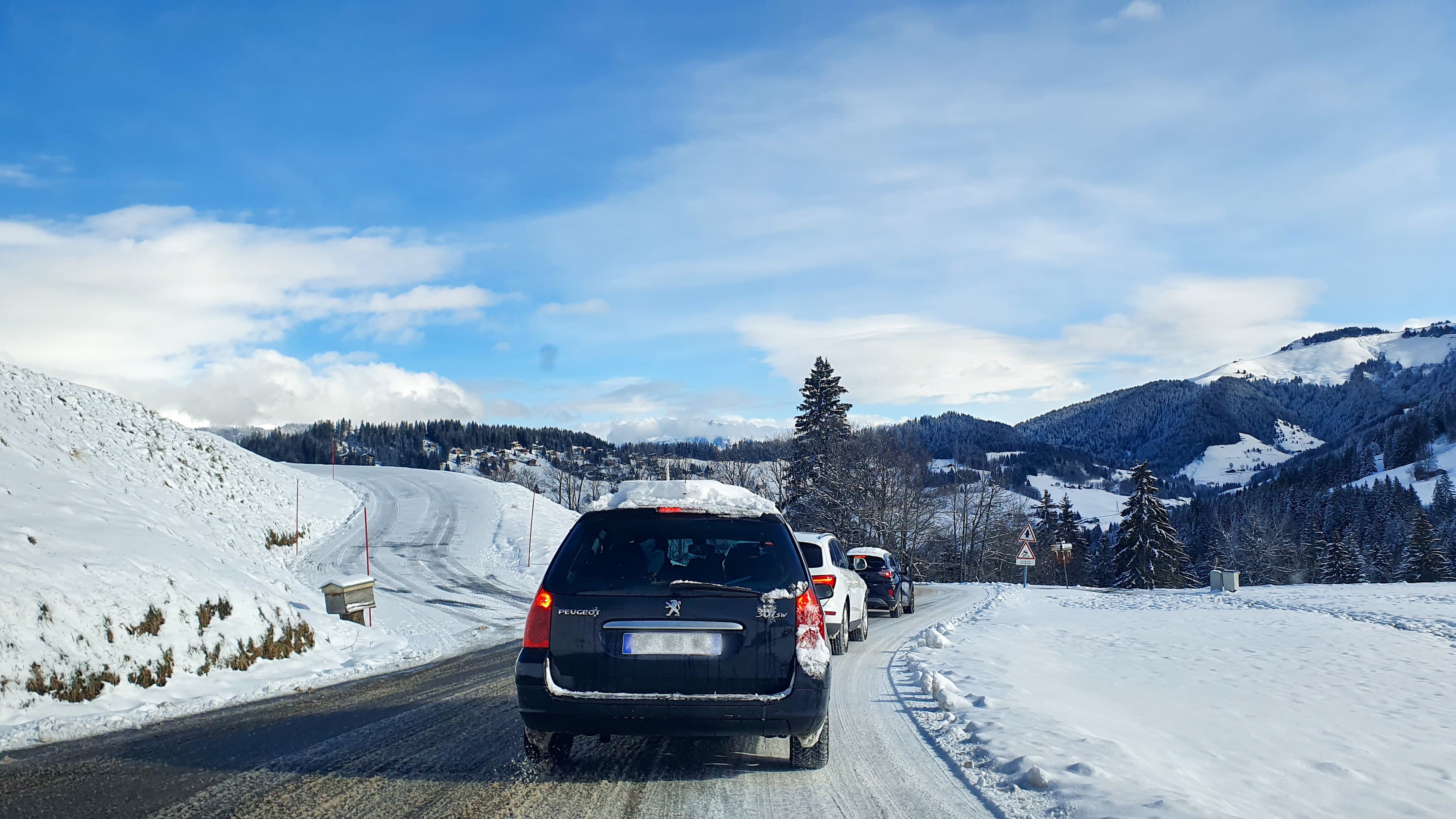 Une file de voitures en direction des pistes de ski dans les Alpes