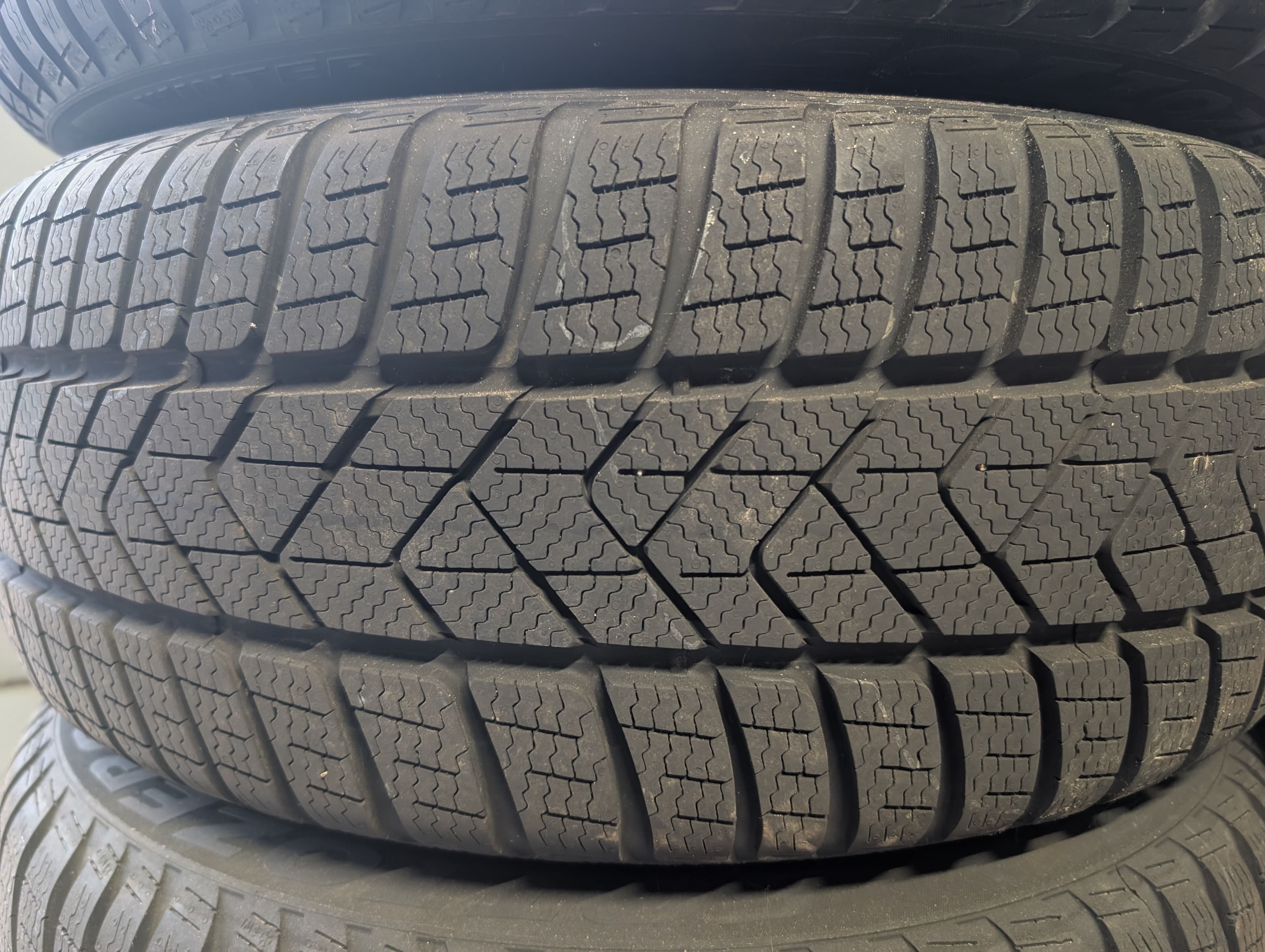 Des pneus hiver stockés en pile dans un garage