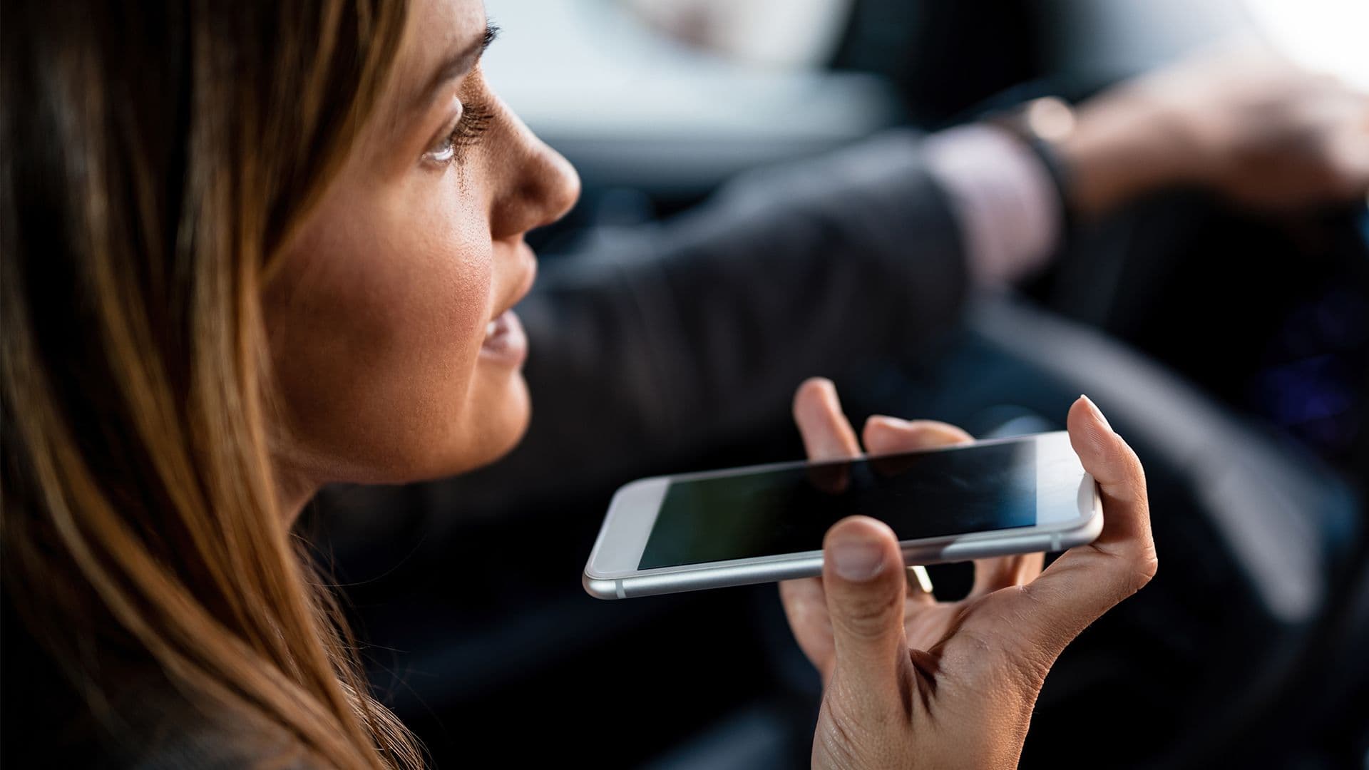 Une photo d'une femme au volant avec son téléphone à la main pour mettre en avant nos questions de quiz