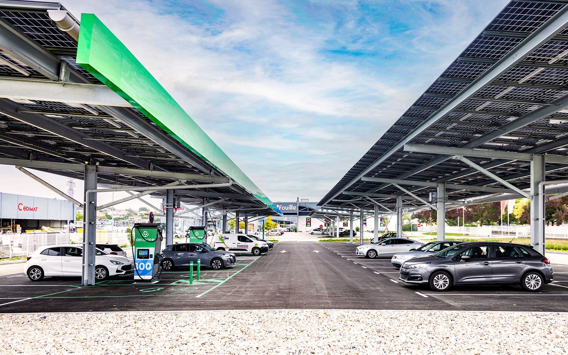 Des voitures électriques sont garées pour se recharger sur une station de recharge équipée de panneaux photovoltaïques.