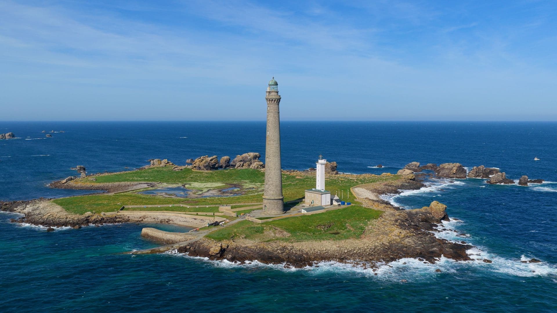 Phare en pierre sur un îlot rocheux battu par la mer